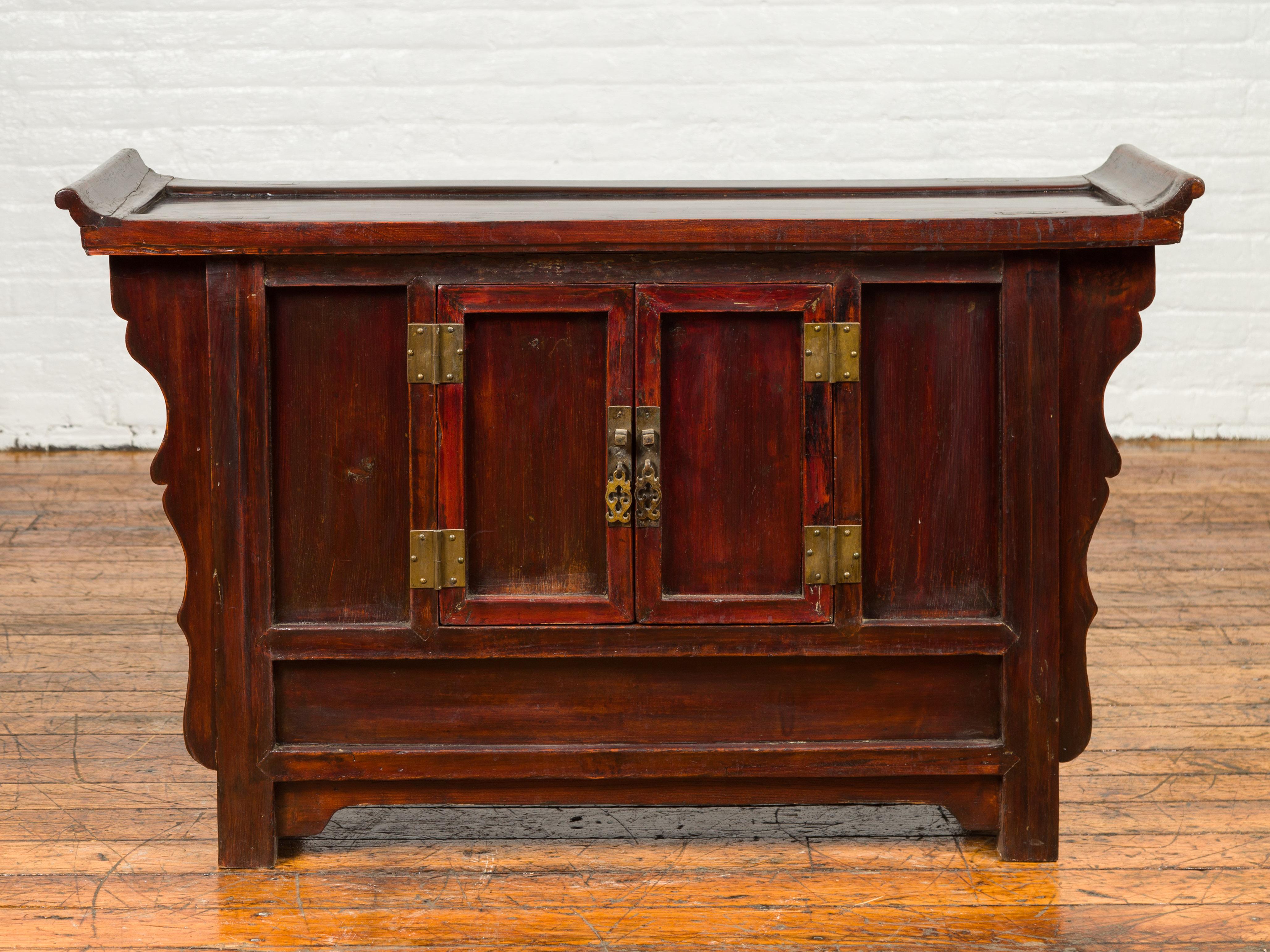 A Ming Dynasty style red rose butterfly console cabinet from the 19th century, with everted flanges, double doors and carved panels. Step into the world of ancient elegance with this Ming Dynasty style red rose butterfly console cabinet from the