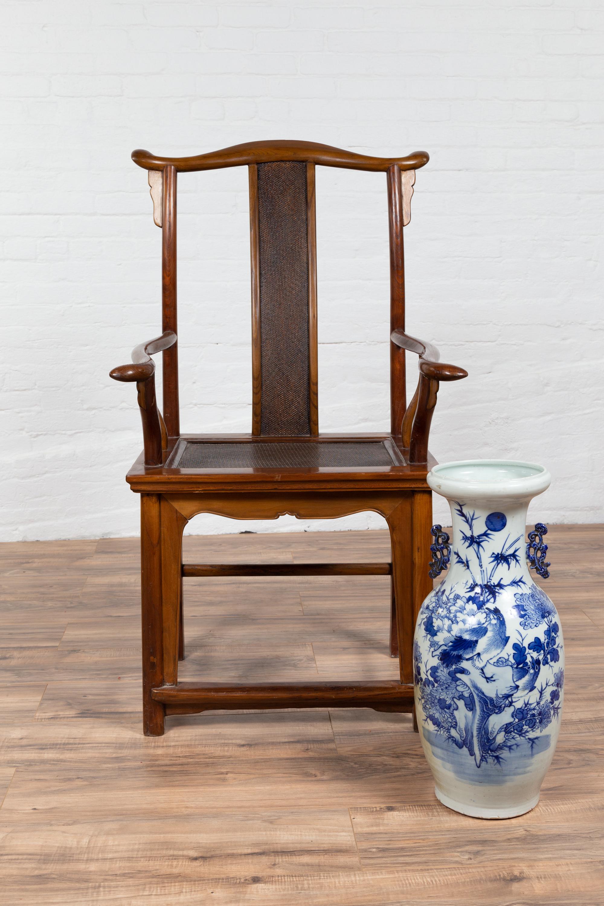 Chaise d'érudit antique de style dynastie Ming, datant du début du 20e siècle, avec dossier et assise en rotin. Cette chaise d'érudit de style dynastie Ming, datant du début du XXe siècle, est un exemple d'élégance raffinée et d'attrait intemporel.