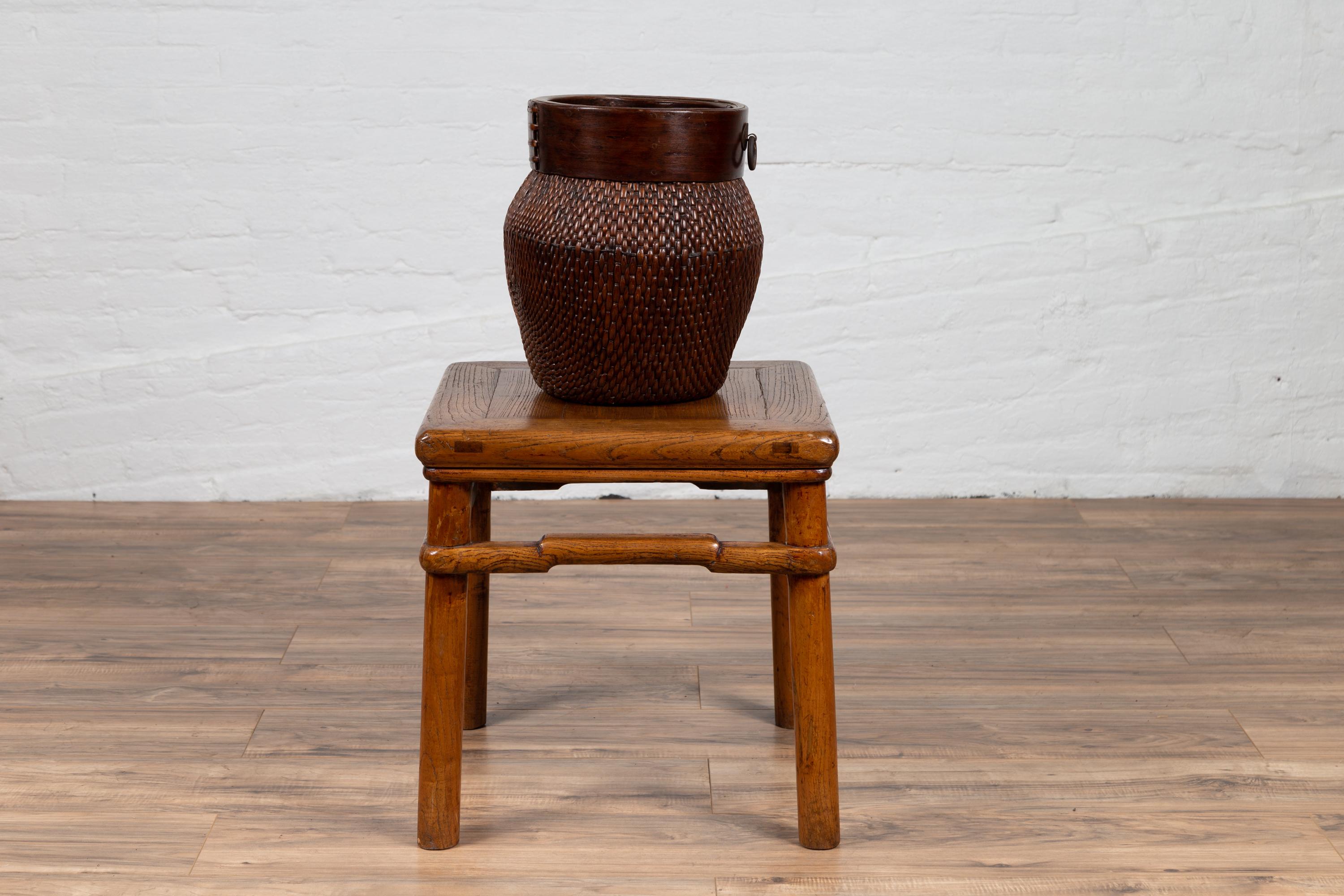 An antique Chinese Ming dynasty style natural wood side table from the early 20th century, with humpbacked stretcher, rich grain design and cylindrical legs. We currently have two tables available, priced and sold individually. Born in China during