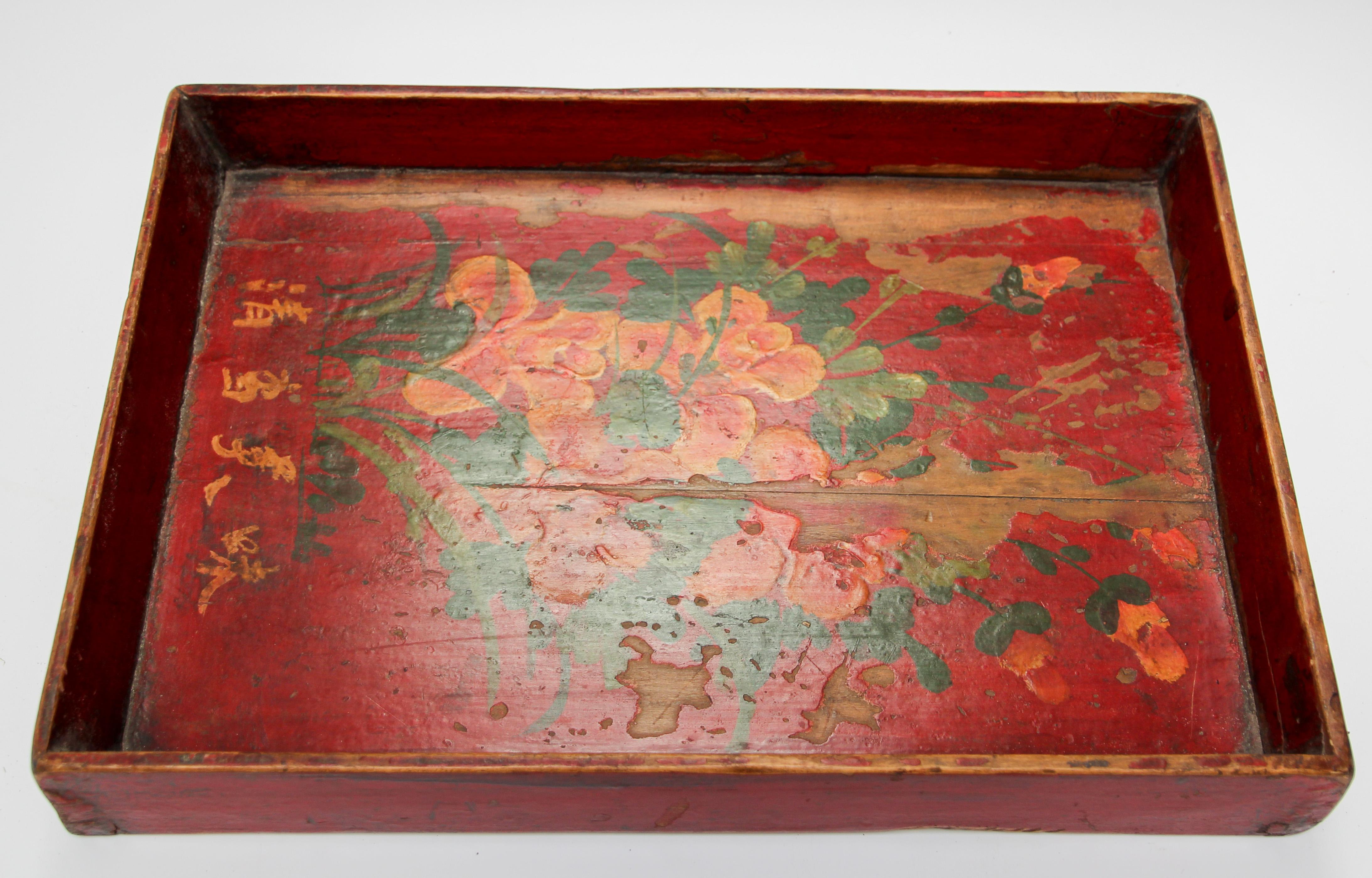 Late 19th century antique wood serving tray hand painted with flowers on red background.
Worn paint and great patina with floral painted design in red and yellow and green with Chinese calligraphy writing.
Well constructed and still strong and