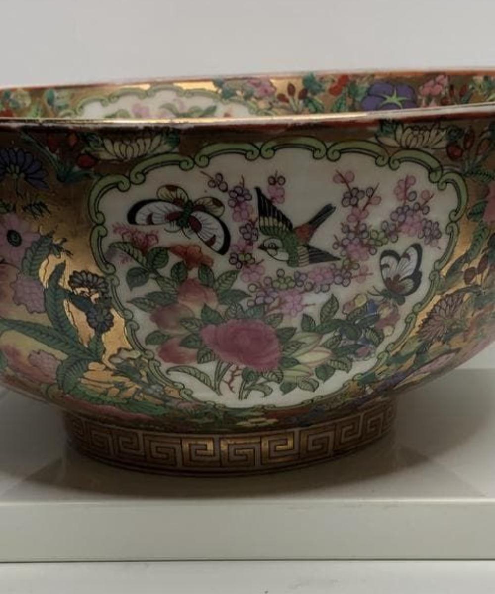 Marked Qian Long Dynasty. Large decorative painted bowl. Constructed from high quality, high temperature fired Chinese porcelain. Features hand applied images of an Asian courtyard scene, surrounded by a bright Oriental fruit and floral motif