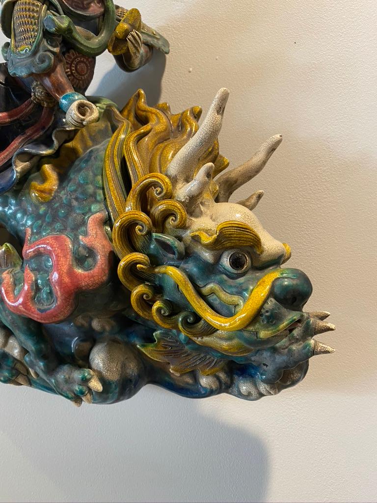 This handmade Chinese roof tile being very colorful is a young man riding a dragon. Hand potted and hand painted. Having a chop mark on the reverse side
very well created.