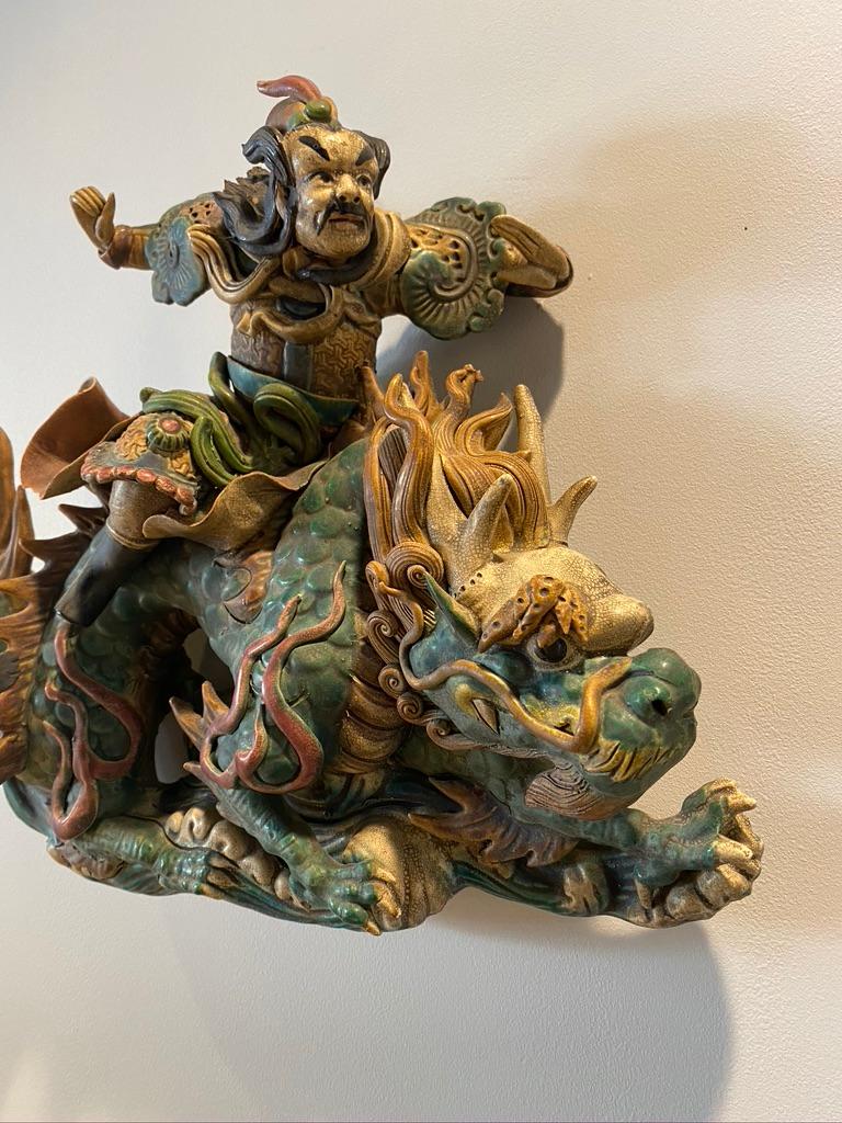 This handmade and hand glazed, painted roof tile is of pottery depicting a warrior riding a large dragon Qing dynasty.