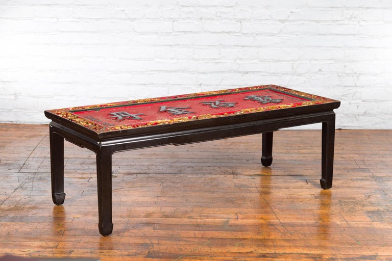 A Chinese antique shop sign with gold and red décor, turned into a coffee table with black horse hoof legs. Created in China, this coffee table captures our immediate attention with its striking red textured ground highlighting black calligraphy,