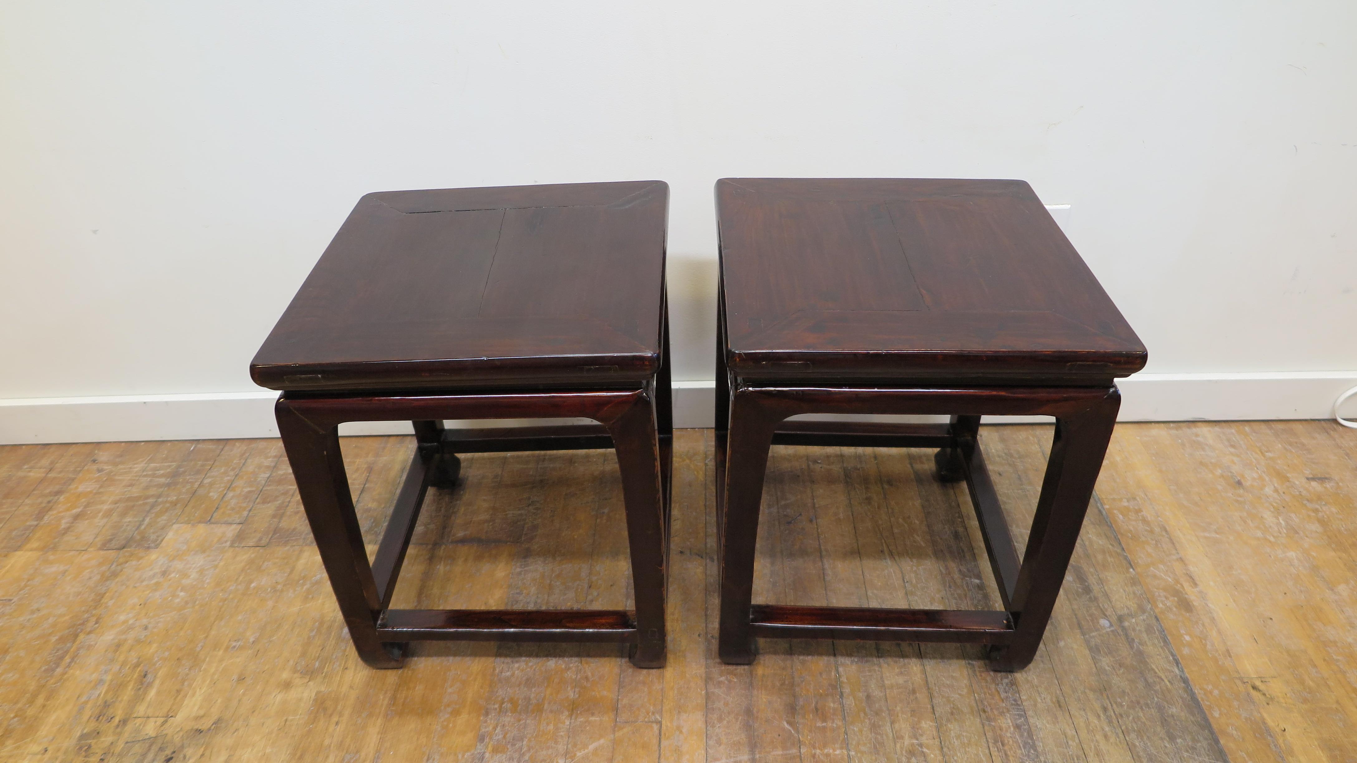 Pair of Chinese antique Ming Dynasty style side tables. Having turned in horse hoofed feet with a square top with central board, sitting above a waisted apron, accented with arched legs and lower stretchers. With clean lines and warm plum lacquer on