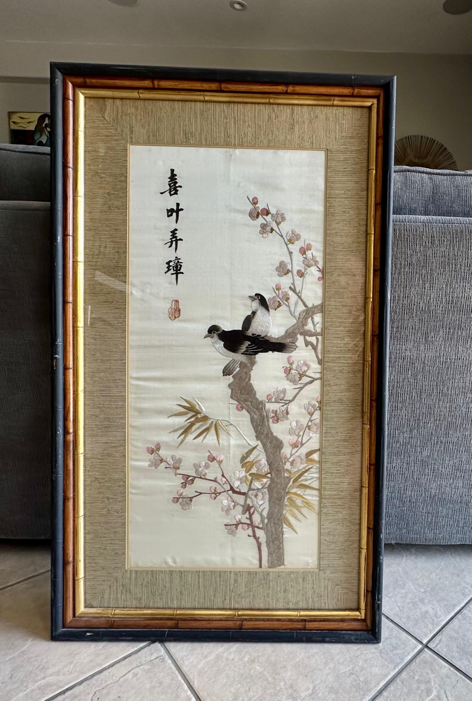 Cuadro alto de seda china bordada, enmarcado y con paspartú, que representa pájaros, flores y arbustos. Firmado con inscripción caligráfica y sello rojo. 