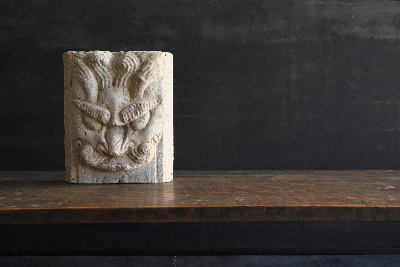 This is a carved stone slab, probably made in China.
What is represented is probably a dragon.
A dragon with a brave face is carved with two raised eyebrows.
It is thought that it was originally a cut-out part of a stone pillar from a temple or a