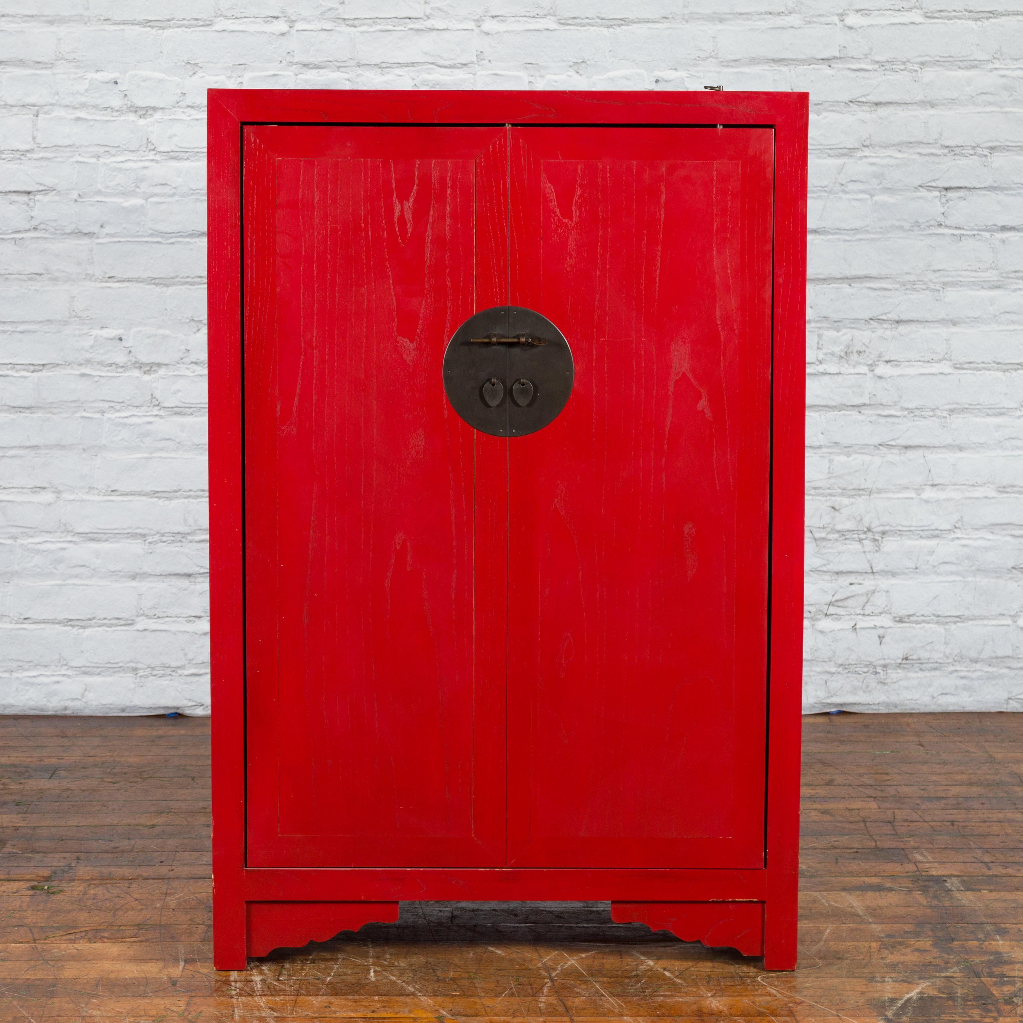 An American Chinese style red lacquered liquor cabinet from the 21st century, with revolving hidden wine rack. Made in the USA, this contemporary liquor cabinet was designed in an antique Chinese style. The cabinet feature a linear silhouette