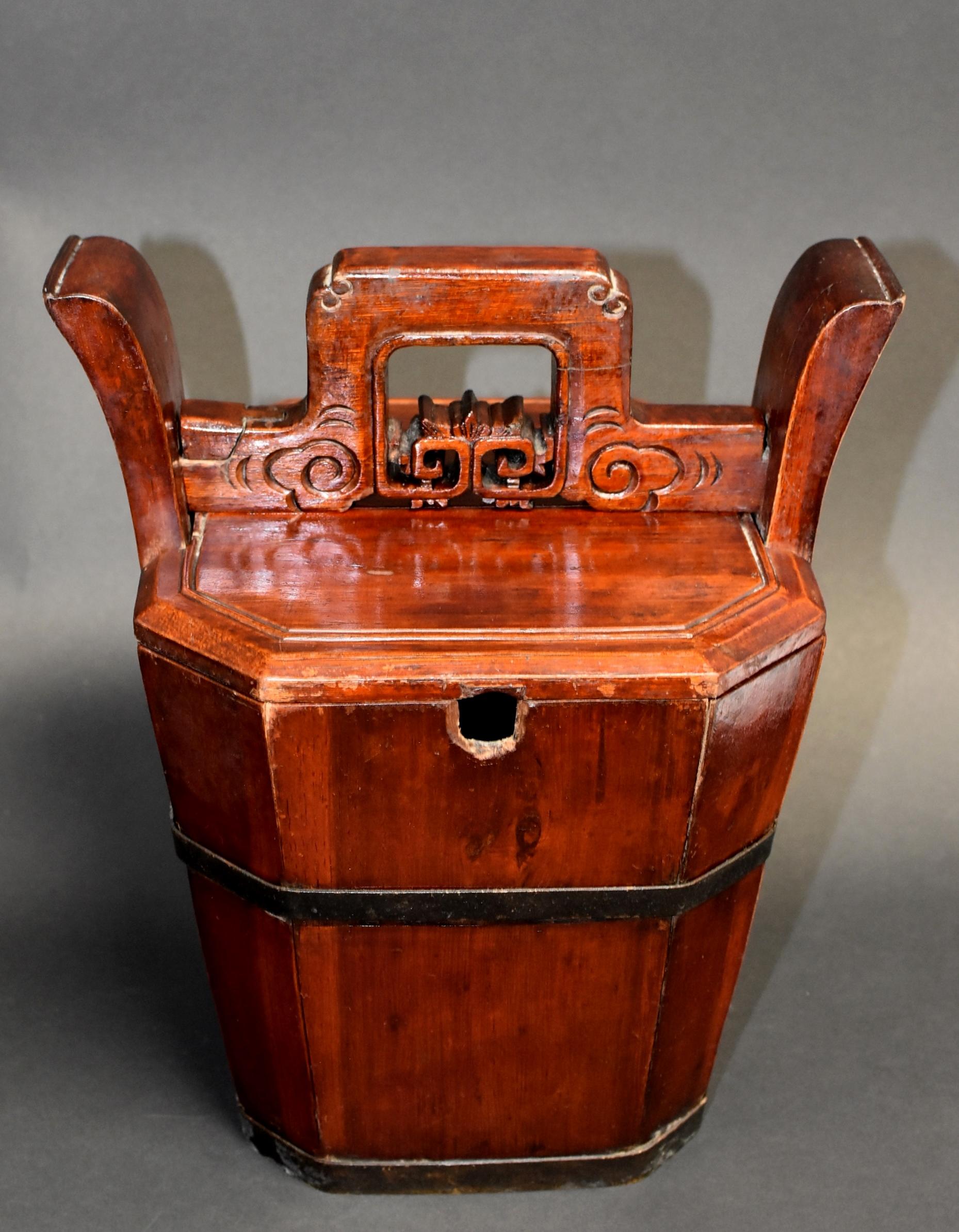 A beautiful 19th century wooden basket designed for holding and carrying a teapot. The handmade hexagonal basket's 6 sides are held together by 2 solid bronze bands. Above the lid lies a carved horizontal bar which acts as the lock to the basket.
