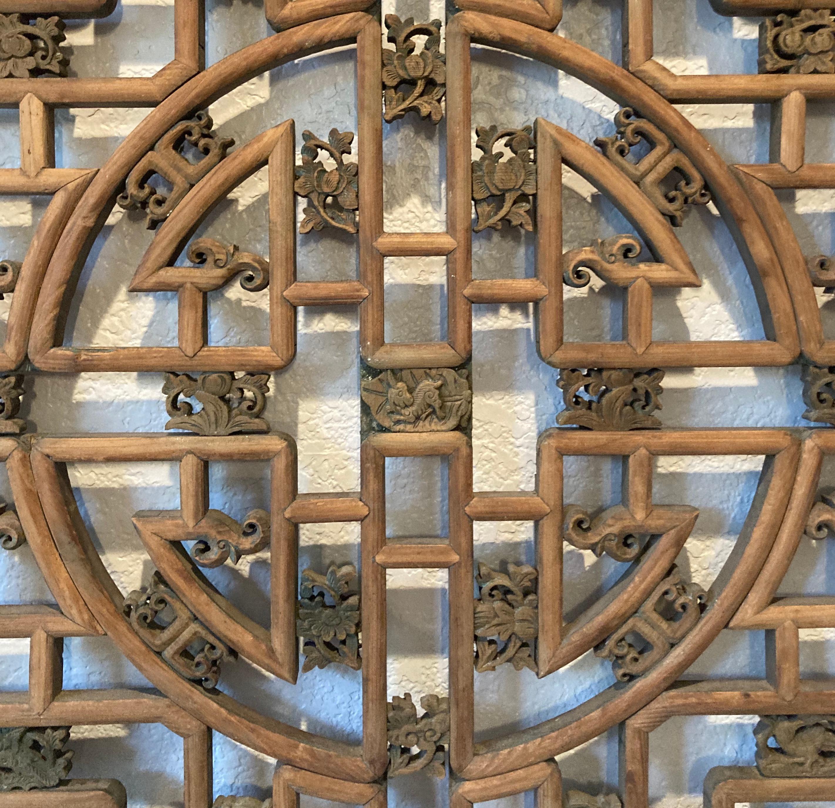 Lattice panel with mitered mortise and tenon joints. Panel includes center circular lattice work, multiple small carved objects with floral motifs, and metal hanging hardware.