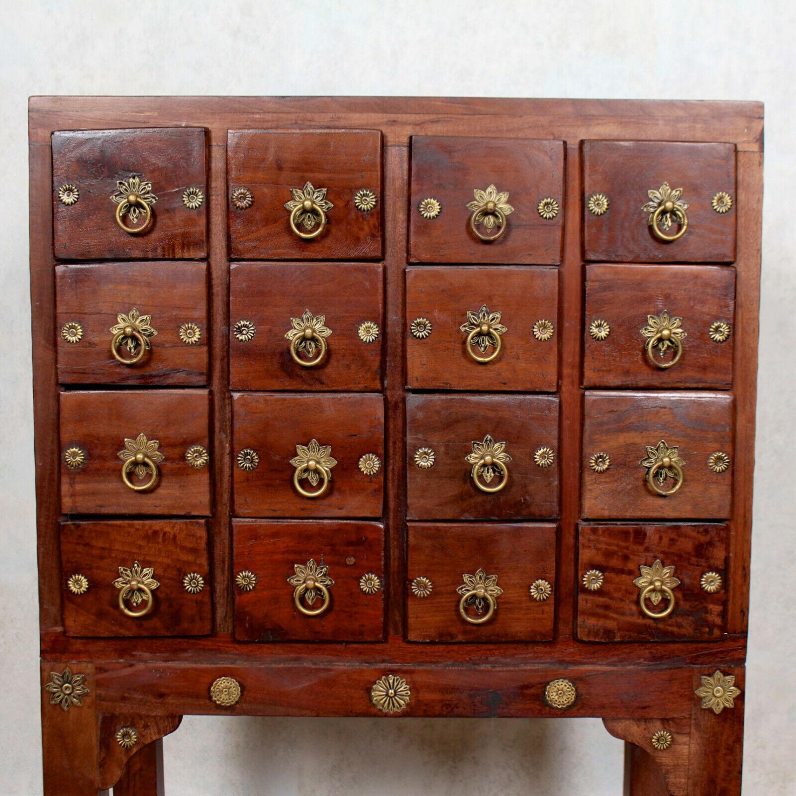 An impressive Chinese apothecary cabinet or spice chest.

Fitted four rows of four short drawers mounted with brass handles and ornamentation, solid interiors flanked by brass roundels to sides. Raised on square block supports and perimeter