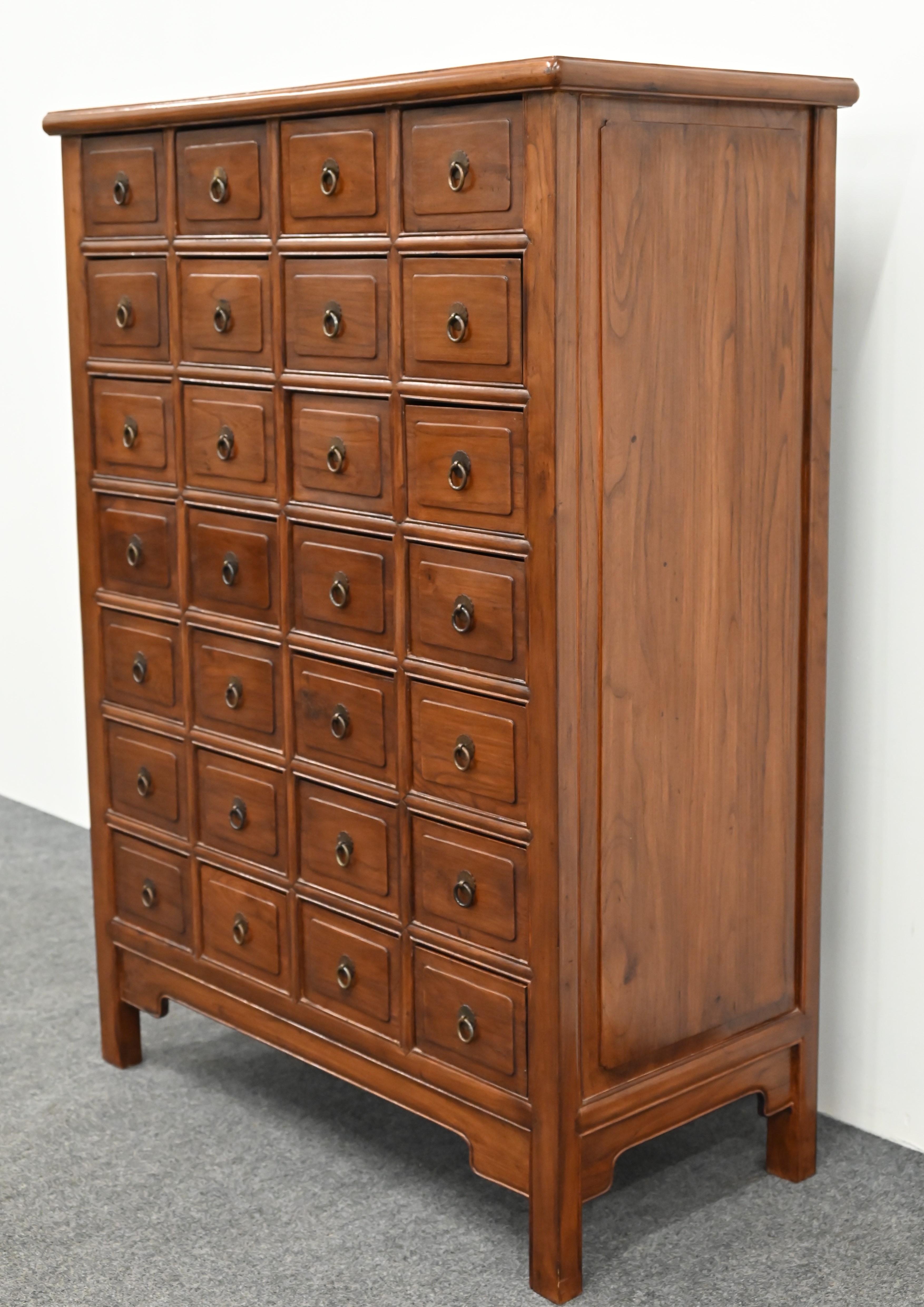 This unique 28-drawer Chinese Apothecary Cabinet has many functional attributes to this handsome piece. This Asian cabinet is designed in the Qing style was most likely made in the late 20th Century. Still has some age and a wonderful color and