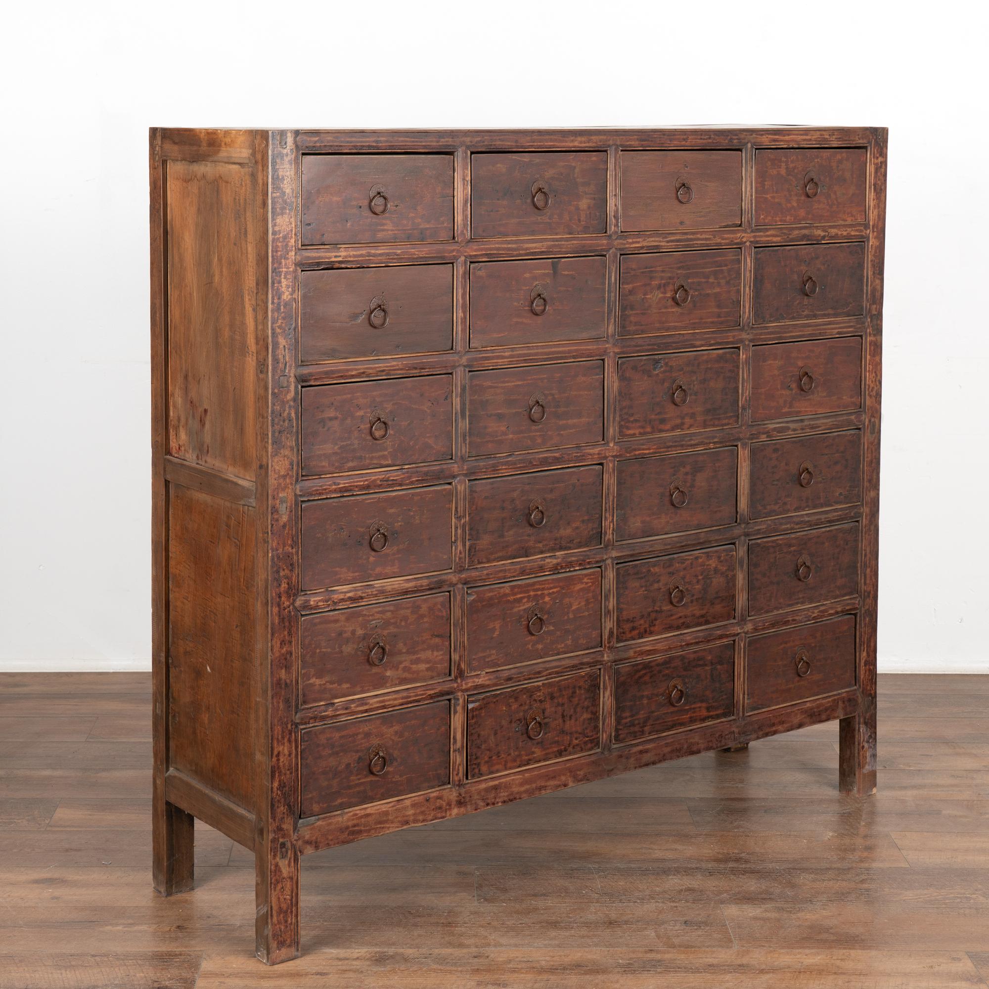 There is something visually mesmerizing about an old apothecary and this unique Chinese cabinet from the 1800's is no exception.
The old brown painted finish has slight red undertones and is accentuated by a hand buffed finish, leaving a warm