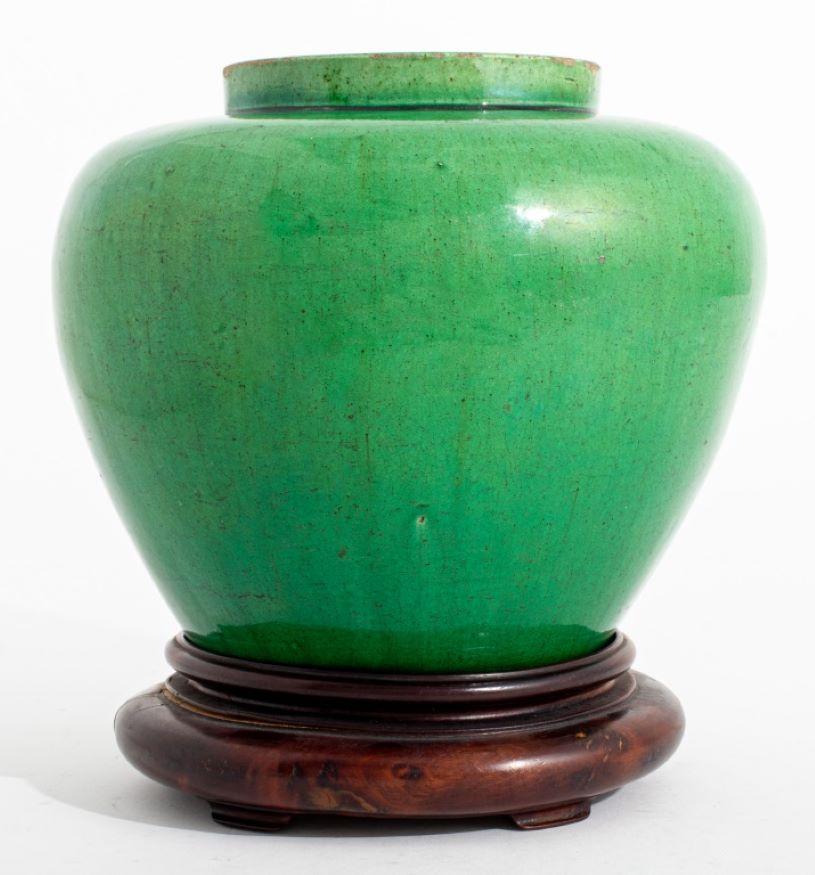 Chinese Apple Green Glazed Ceramic Jar, yellow glazed interior, together with a carved hongmu stand. vase: 6.5