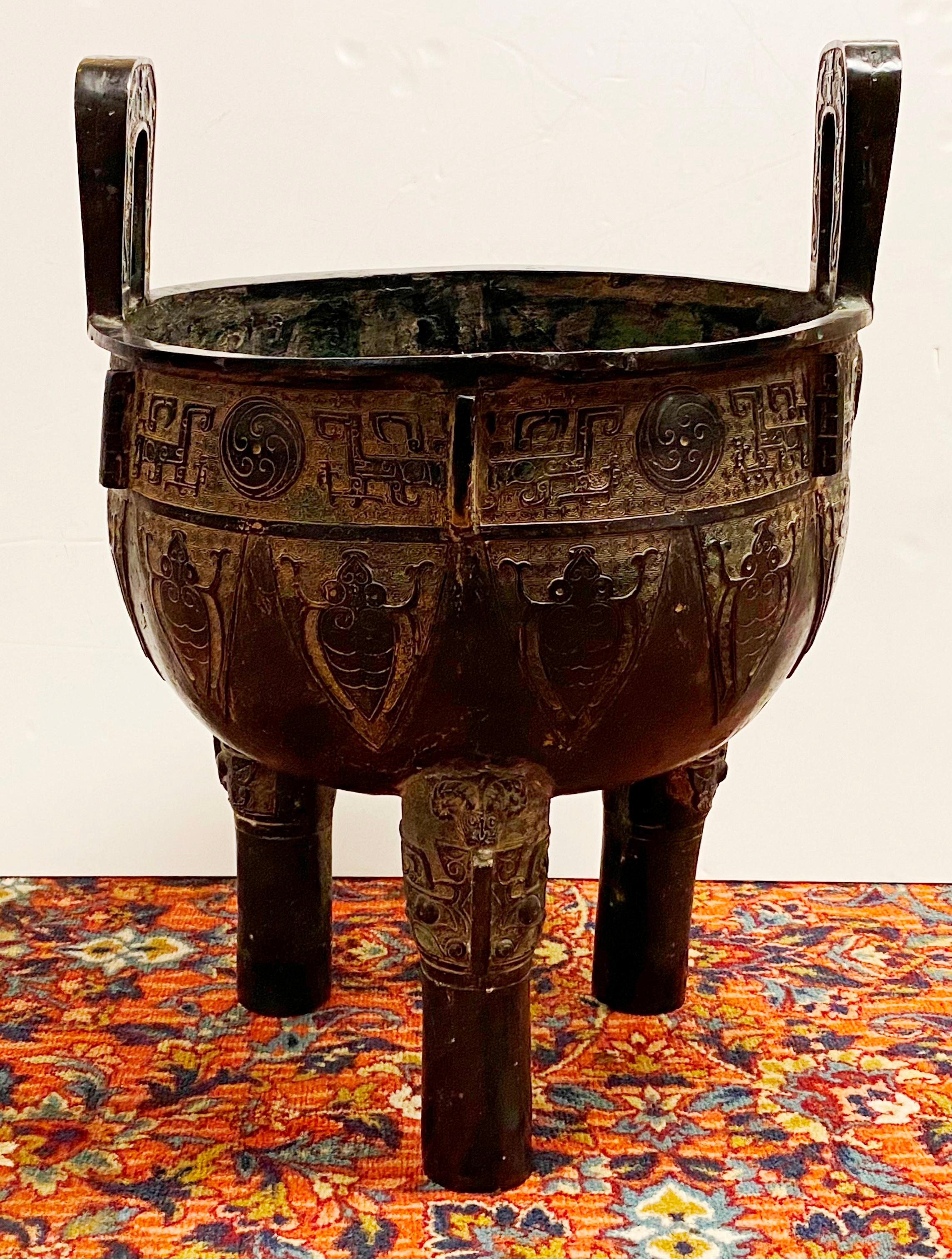 Chinese Archaic style monumental bronze tripod vessel with elaborate ornamentation and scarab motifs, marked on the bottom, circa early 20th century.