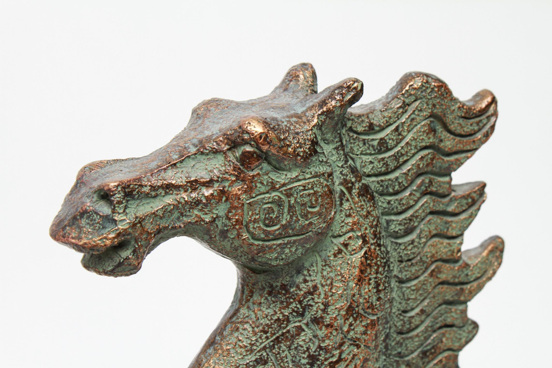 Chinese archaic style running horse sculpture, one side incised with geometric patterns. The piece is made of composite material and rests atop a black rectangular base. In great vintage condition with age-appropriate wear.