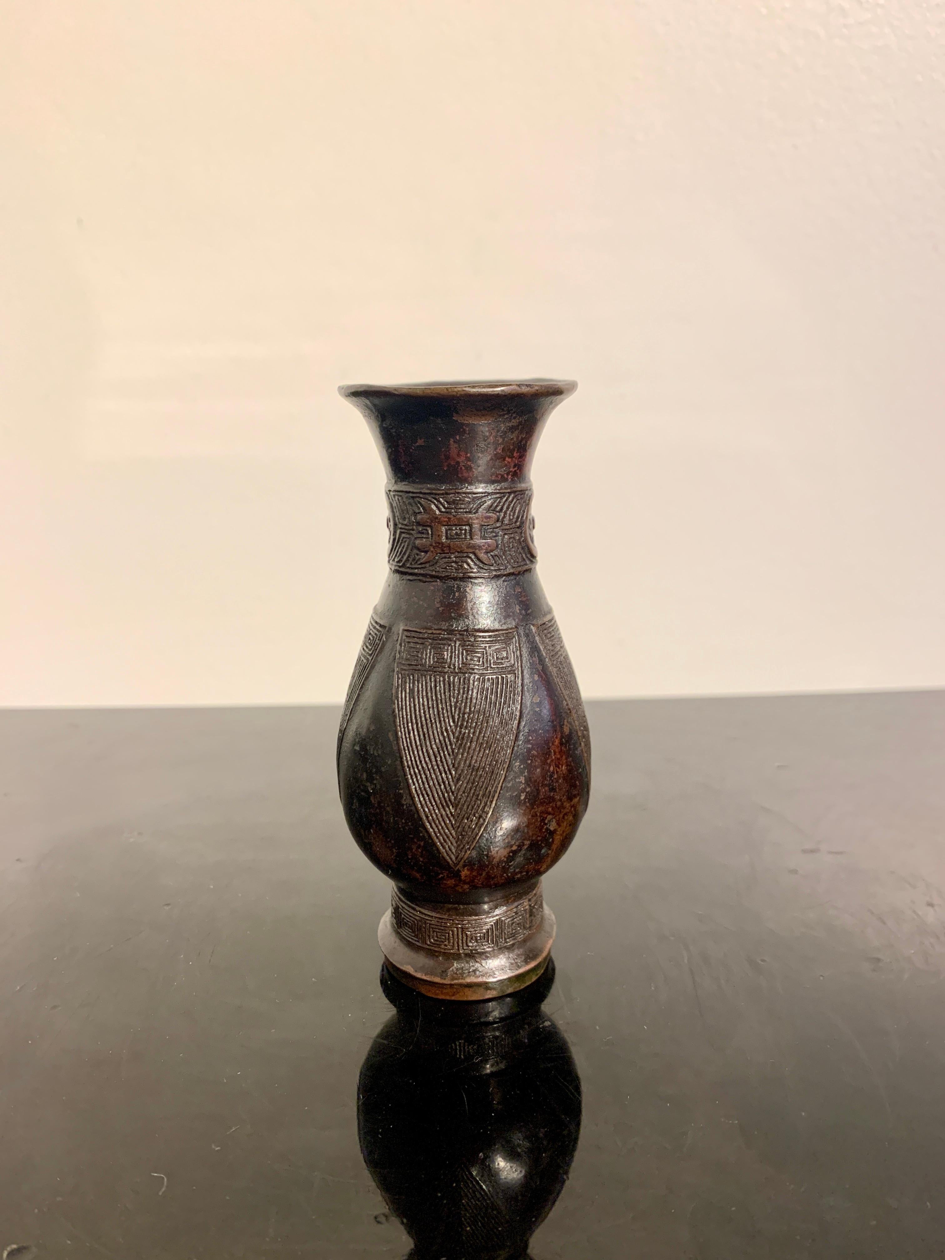 Petit vase d'érudit archaïque en forme de zun, dynastie Ming à Qing, XVIIe siècle, vers 1650, Chine.

Le petit vaisseau aux proportions élégantes et merveilleusement moulé. Le petit vase d'érudit prend la forme d'un zun archaïque miniature, un