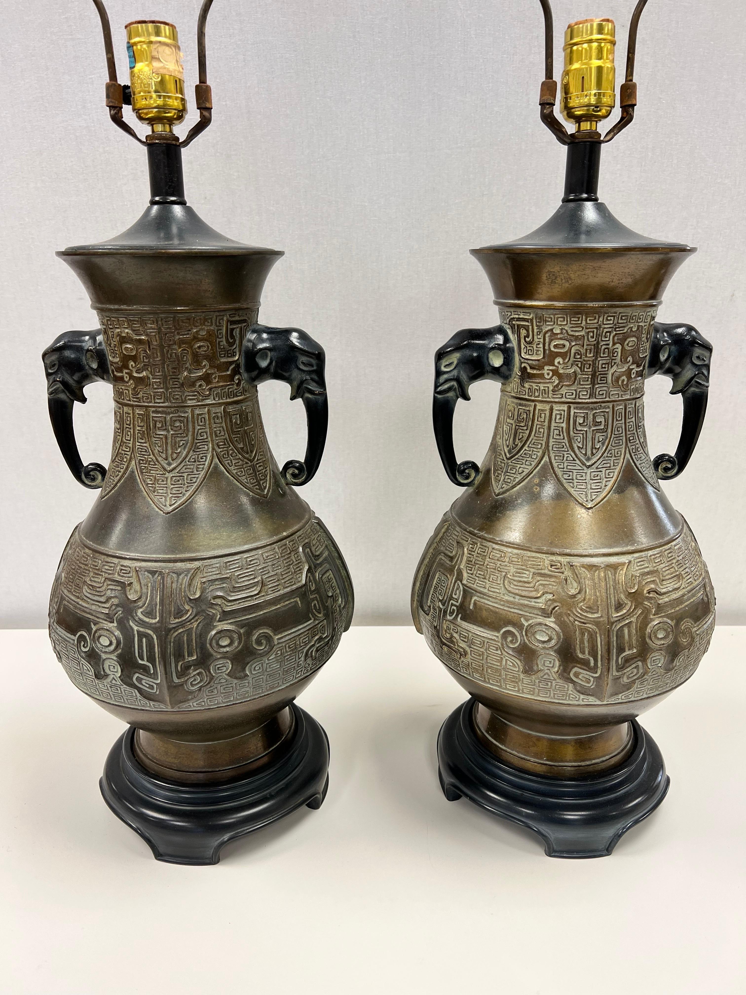 Vintage Chinese archaistic urn form lamps having molded geometric designs and elephant handles. 22.5”h to top of socket.