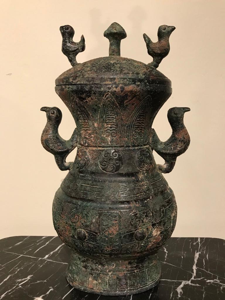 A Chinese bronze lidded ritual vessel modeled after a Late Warring States, 3rd-2nd century BC original. With four whimsical birds form handles as well as a mushroom shaped ornament on the lid. The entire surface covered with incised Archaistic