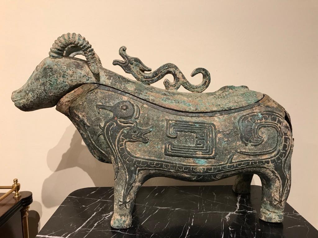 A wonderful Chinese Archaistic lidded wine vessel in the rare form of a ram, the surface decorated with dragons, birds and fish as well as stunning geometric designs, the top with a kui dragon for a handle. In late Shang dynasty style, 13th-11th