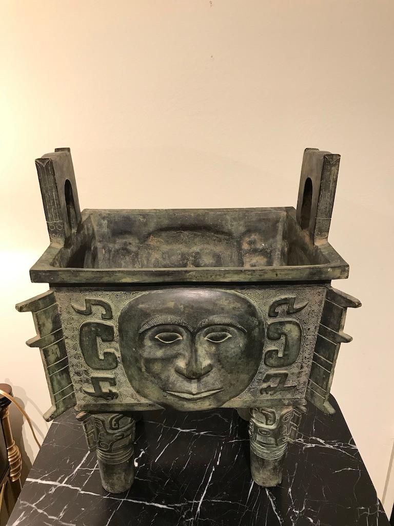 A finely cast Chinese Shang style bronze ritual vessel known as a fangding. With faces on all four sides, this is a wonderful decorative piece which could also be used as a planter or jardinière. A very handsome and compelling piece for use on a