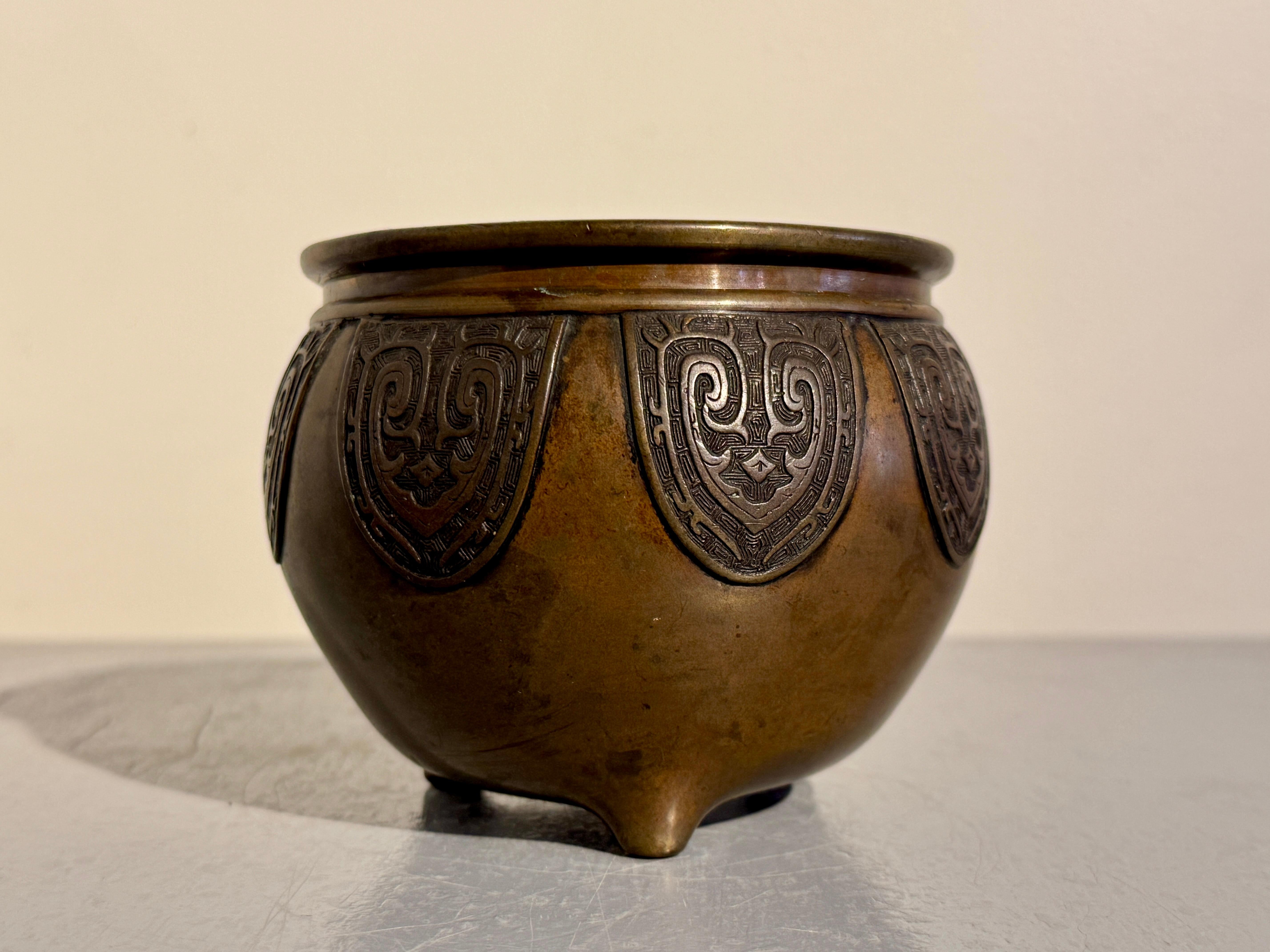 A small and well cast Chinese archaistic bronze tripod incense burner, censer, late Qing Dynasty, circa 1900, China.

The small censer features a squat and bulbous body, very short neck, and slightly everted mouth, all set on three short feet. The