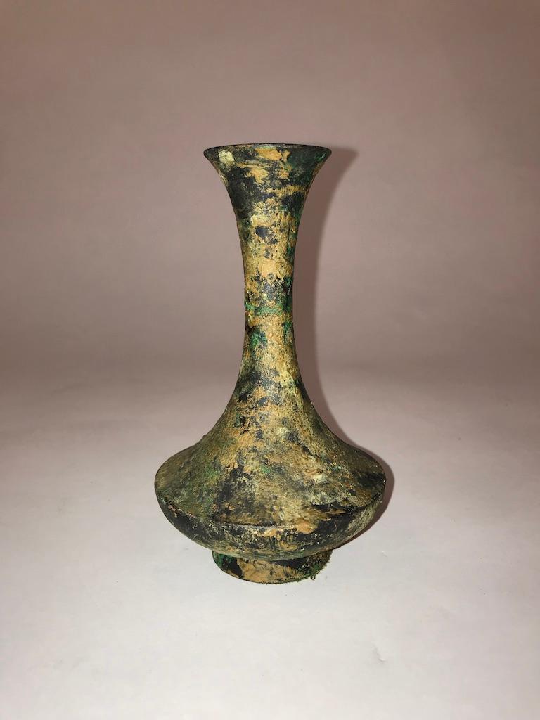 A beautifully shaped trumpet-form Archaistic bronze bottle or vase with. This piece has a very appealing profile and nice color. The surface covered with various encrustation and some verdigris patina, late 19th-early 20th century.