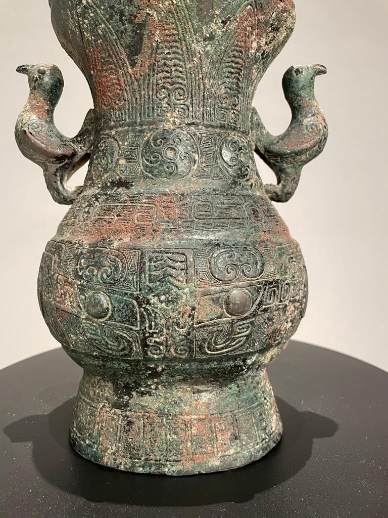 A Chinese bronze lidded ritual vessel modeled after a Late Warring States, 3rd-2nd century BC original. With four whimsical bird form handles as well as a mushroom shaped ornament on the lid. The entire surface covered with incised Archaistic