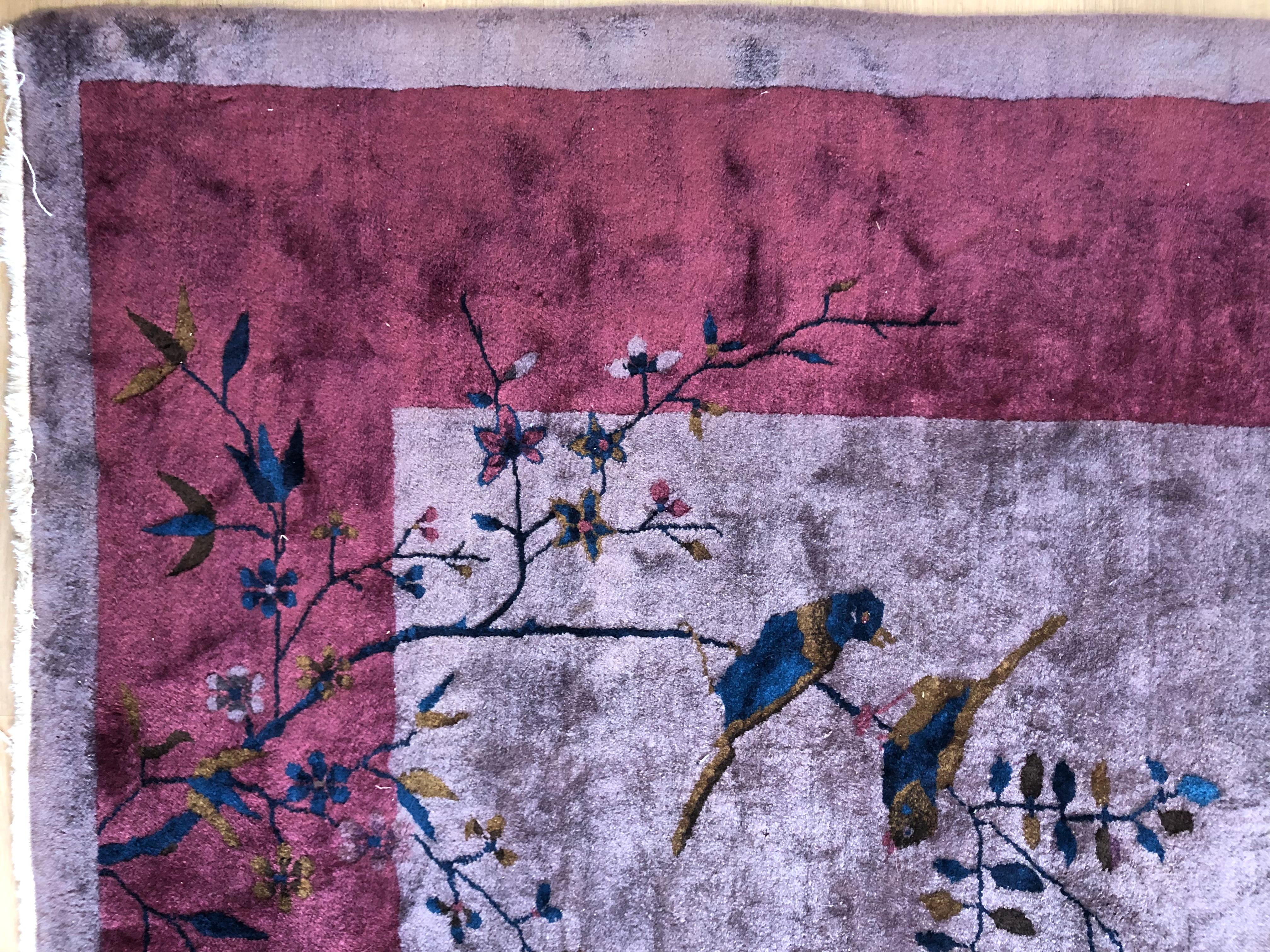 Spectaculaire tapis chinois Art déco avec un fond violet inhabituel et une bordure de mûres, les bords extérieurs avec des détails de la nature, y compris des fleurs, des insectes, des papillons et des oiseaux. Circa 1930.
Ce tapis présente une