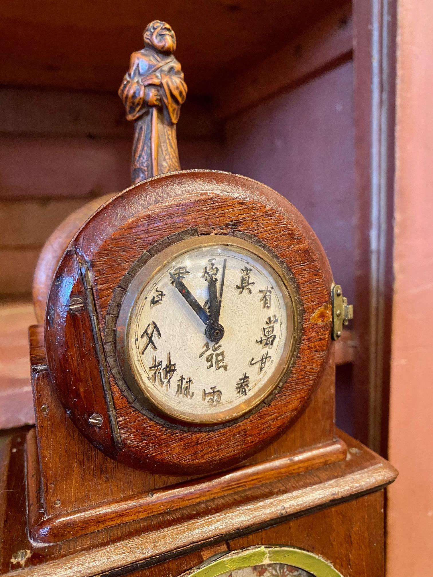 Pendule à manteau en acajou sculpté de style Art Nouveau à Art Déco, datant du début du siècle, avec une horloge mécanique à remontoir d'époque, présentant une figure d'Immortel sur le dessus, des chiffres chinois sur le cadran, des panneaux peints,