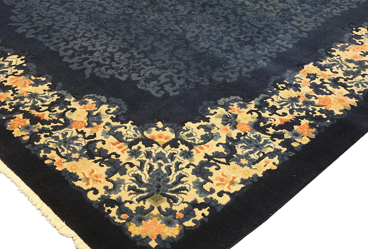 This large Art Deco Chinese Rug By Walter Nichols is a breathtaking masterpiece that exudes elegance and opulence, bringing the grandeur of ancient Chinese artistry into your home. Measuring generously, this rug is a statement piece, designed to