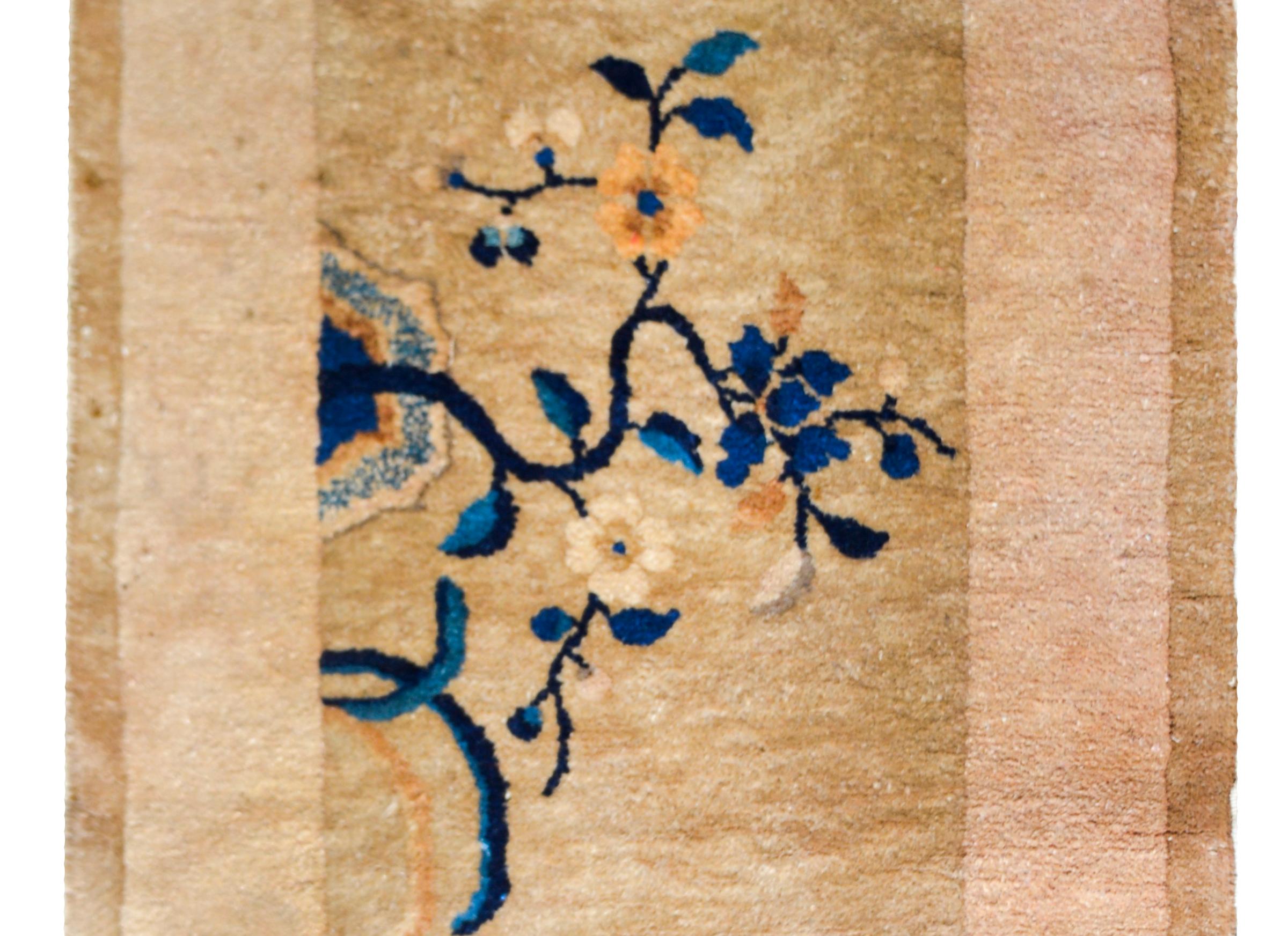 Ein schöner chinesischer Art-Déco-Teppich aus dem frühen 20. Jahrhundert mit einem champagnerfarbenen Feld, das von einer kontrastierenden champagnerfarbenen Bordüre umgeben ist, und beide mit indigo- und rosafarbenen Kirschblüten überlagert sind.