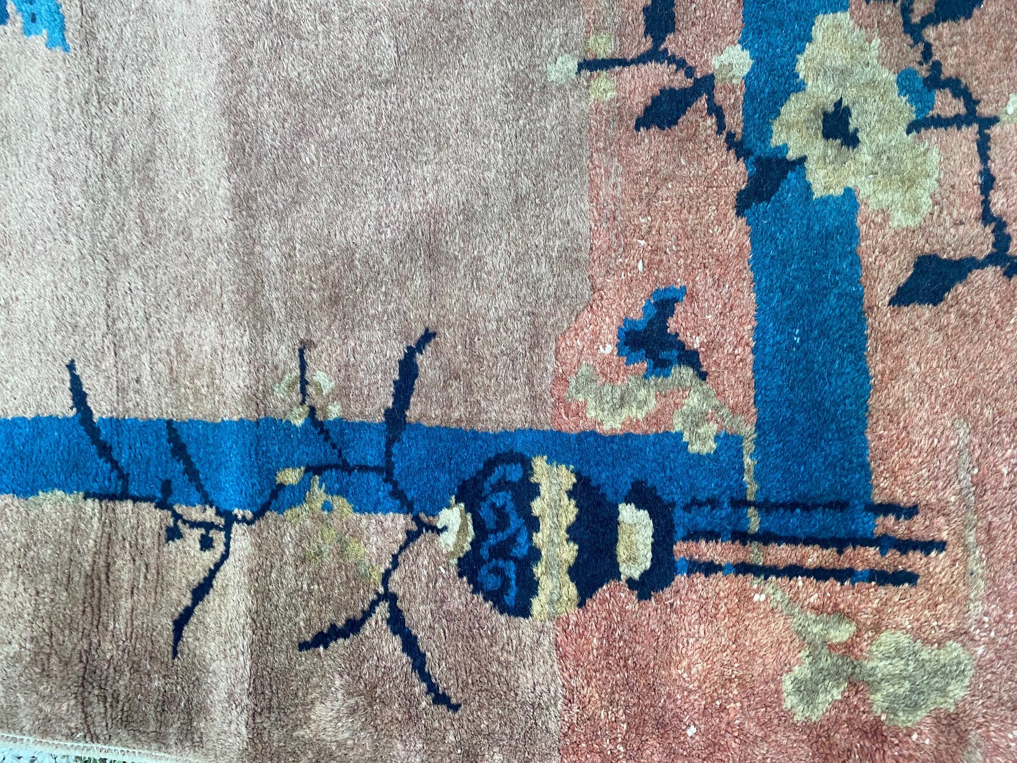 Antique Chinese Art Deco scatter rug, circa 1920, a hand knotted wool carpet featuring cobalt and sky blue floral sprigs on a dark salmon ground. In excellent condition.

Measures: 3 ft x 5 ft.