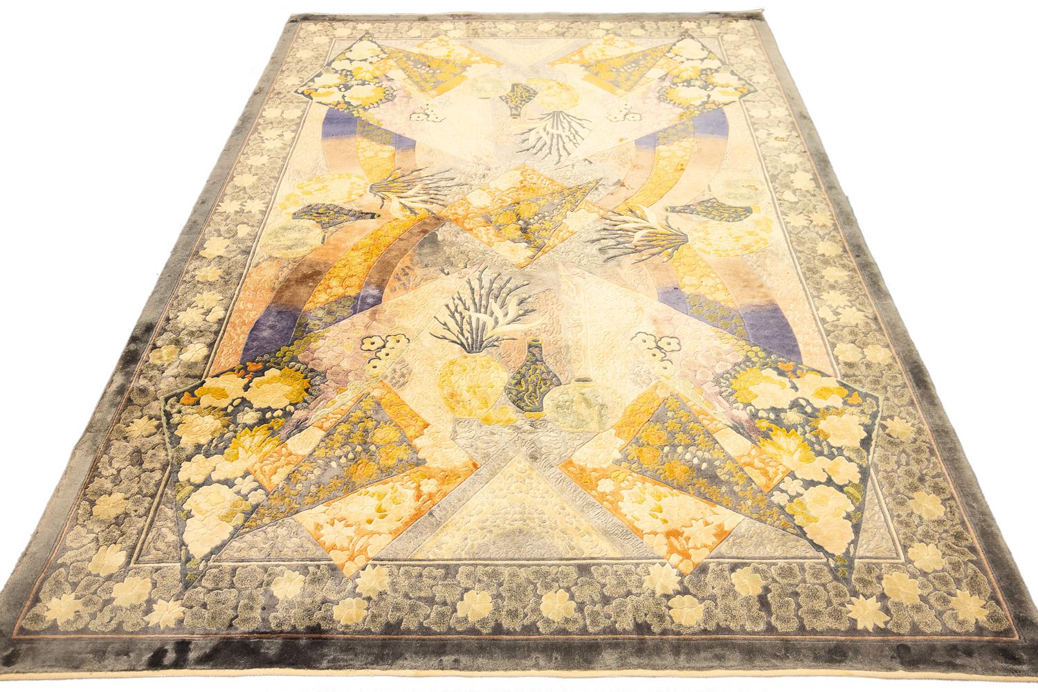 This is a semi-antique hand-knotted silk Chinese rug with an Art Deco design woven circa 1970 - 2000 and measures 241 x 167 CM in size. Its field is made with a combination of geometric panels which are decorated with floral motifs alongside