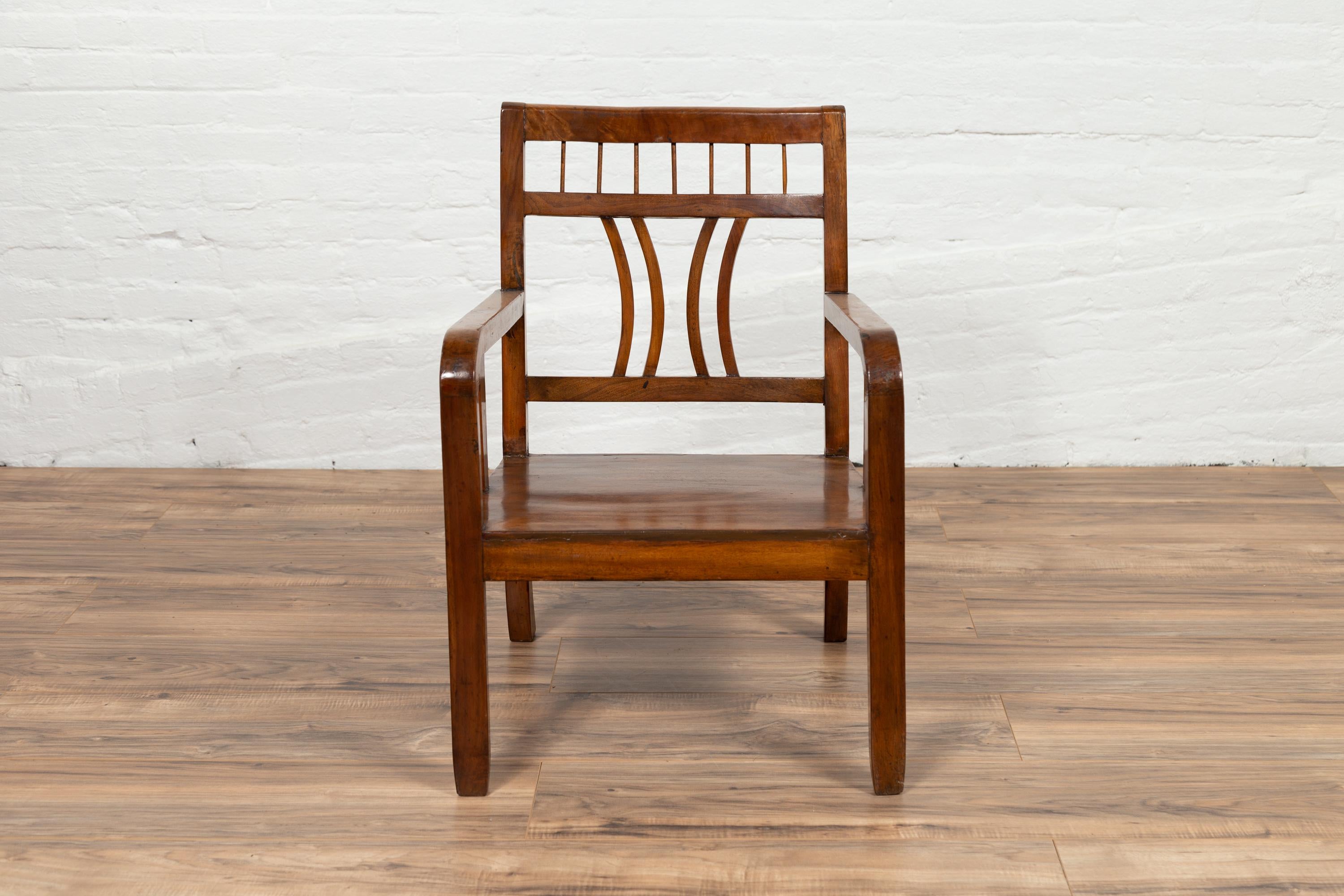 A Chinese vintage Art Deco style elmwood armchair from the mid-20th century, with pierced back and brown patina. Experience the elegant fusion of Art Deco design and traditional elmwood craftsmanship with this vintage armchair from the mid-20th