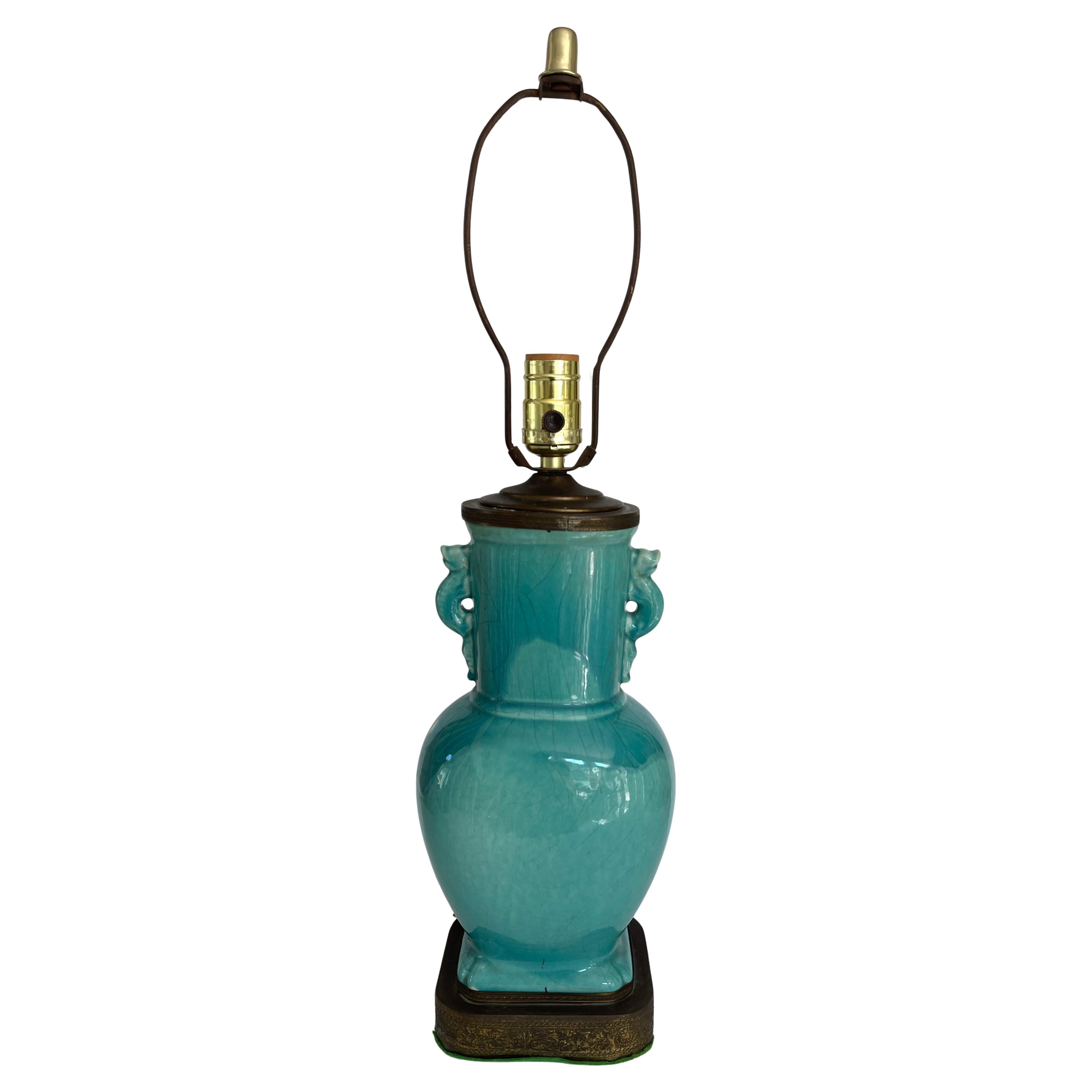 Chinese Art Deco turquoise craquelure porcelain vase lamp with stylised
 foo dog handles. Original brass base and lamp cap. 