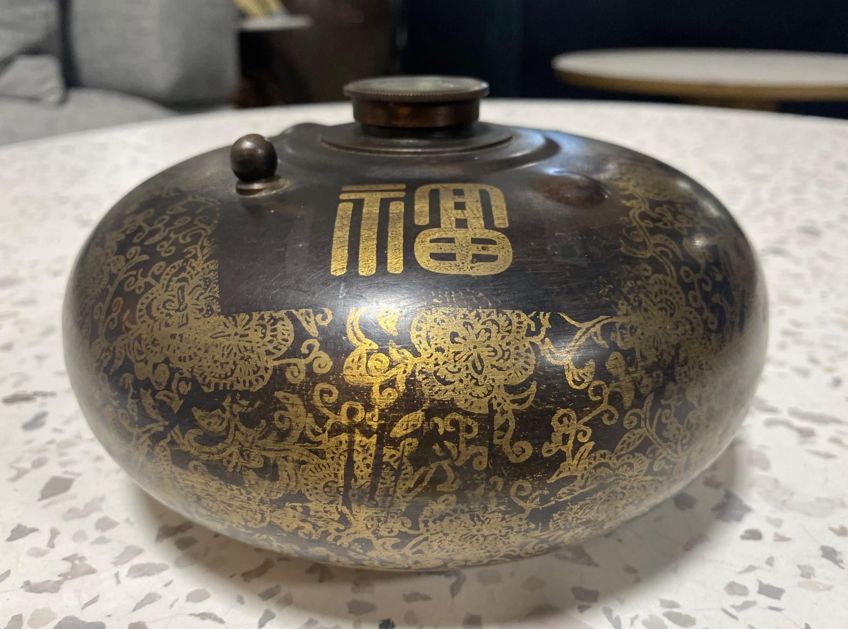 Una bolsa de agua caliente china de finales de la dinastía Qing (1644-1911), bellamente decorada, utilizada originalmente para calentar la cama o el cuerpo.  Esta pieza es de latón (podría ser bronce, pero creemos que es latón).  La pieza está