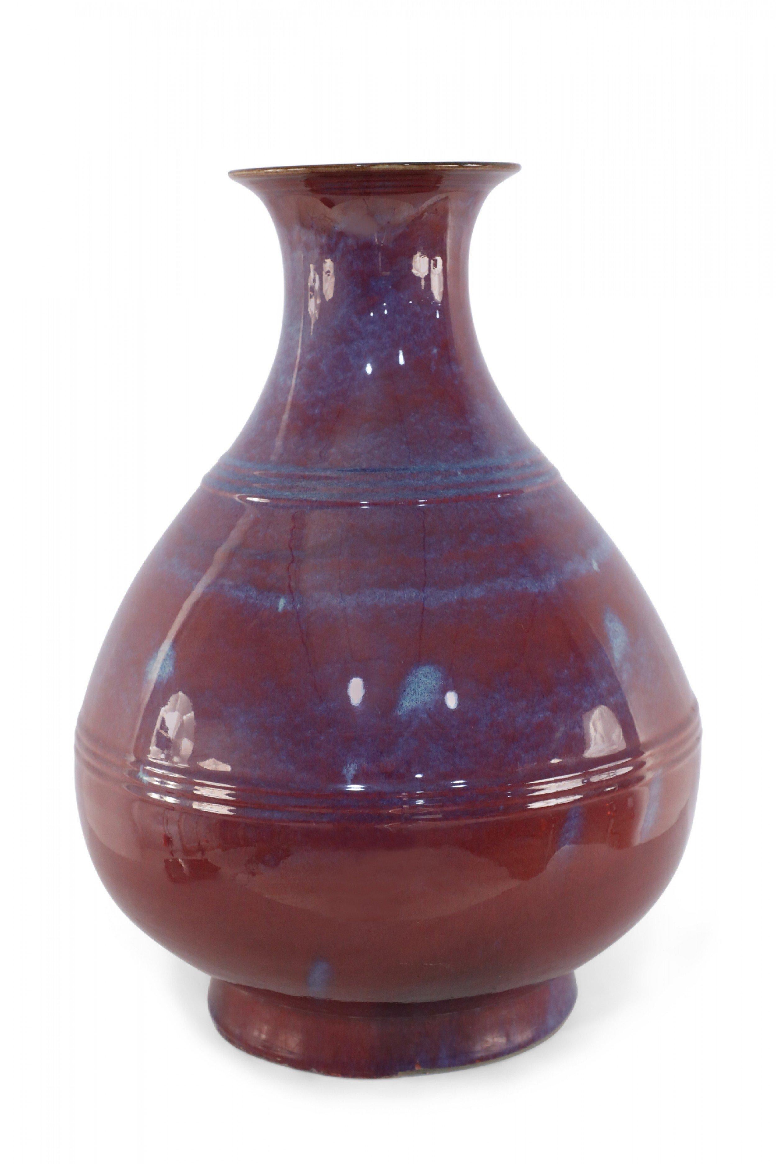 Vaso cinese a bulbo realizzato con uno smalto che si trasforma dopo la cottura in forno, lasciando trasparire tracce di blu attraverso il colore principale melanzana/viola.

Condit: Buono; Usura coerente con l'età e l'utilizzo