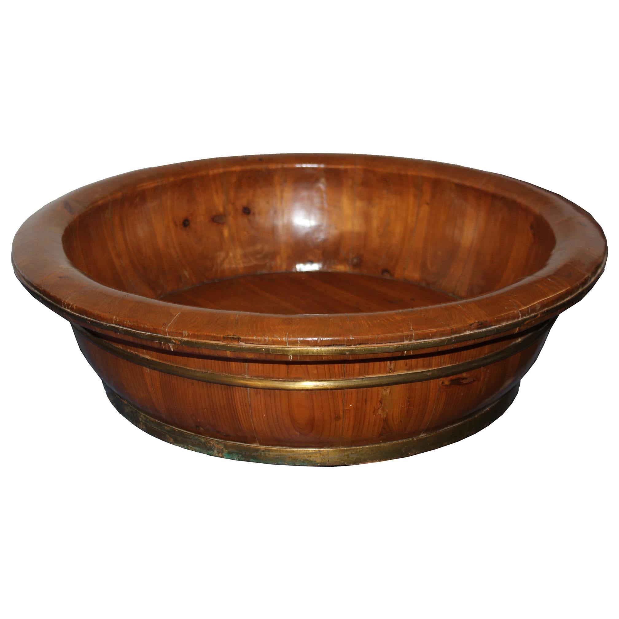 Large vintage elm wood baby bathtub with bronze rings on the outside can be used to display plants or orchids on a dining room table.