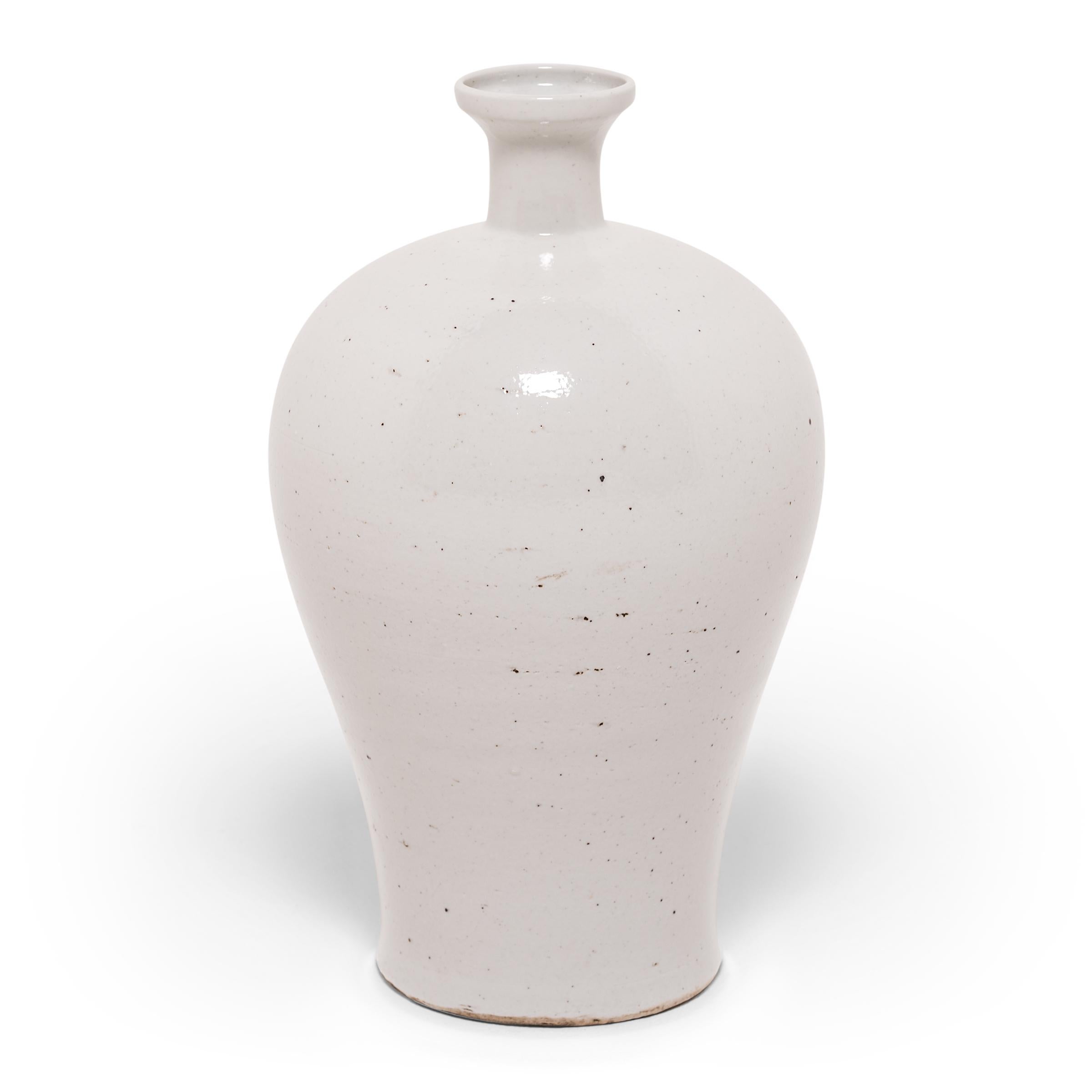 Meiping vases were traditionally used to hold the branches of plum trees, celebrated in China as symbols of strength and longevity. This contemporary update, made in China's Zhejiang province, streamlines the meiping design, cloaking it in a milky