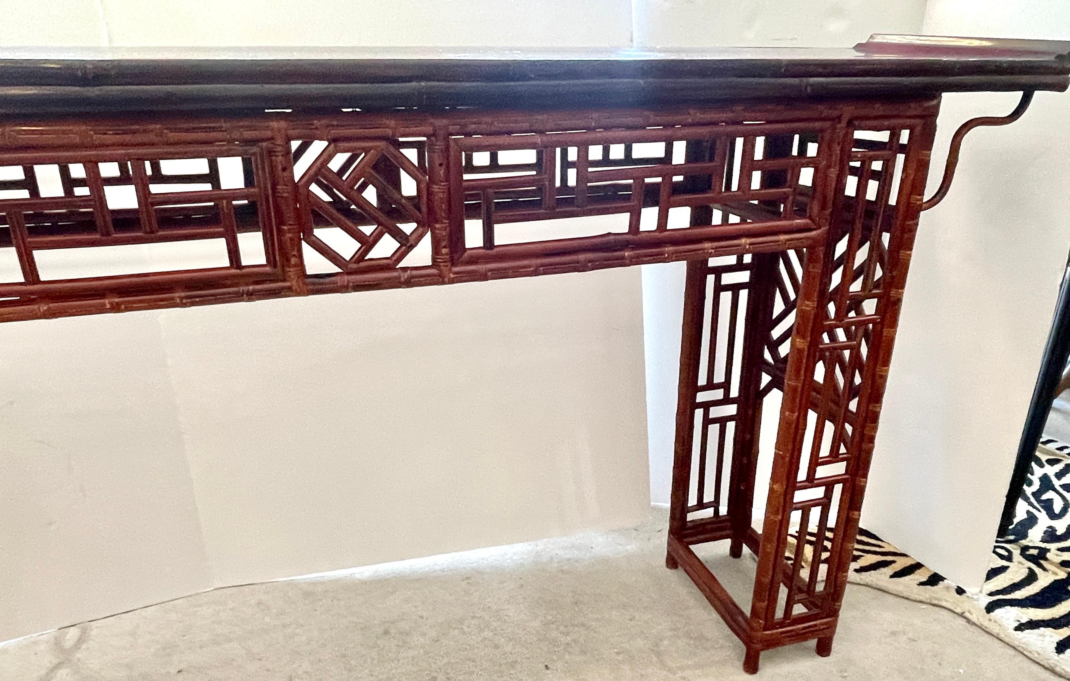 Appena arrivata, questa spettrale console d'altare cinese di bambù della fine del XIX secolo, nella nota serie  Stile traforo del Brighton Pavilion.
Questo antico tavolo d'altare cinese in bambù ha le estremità estroflesse, il piano è in legno di
