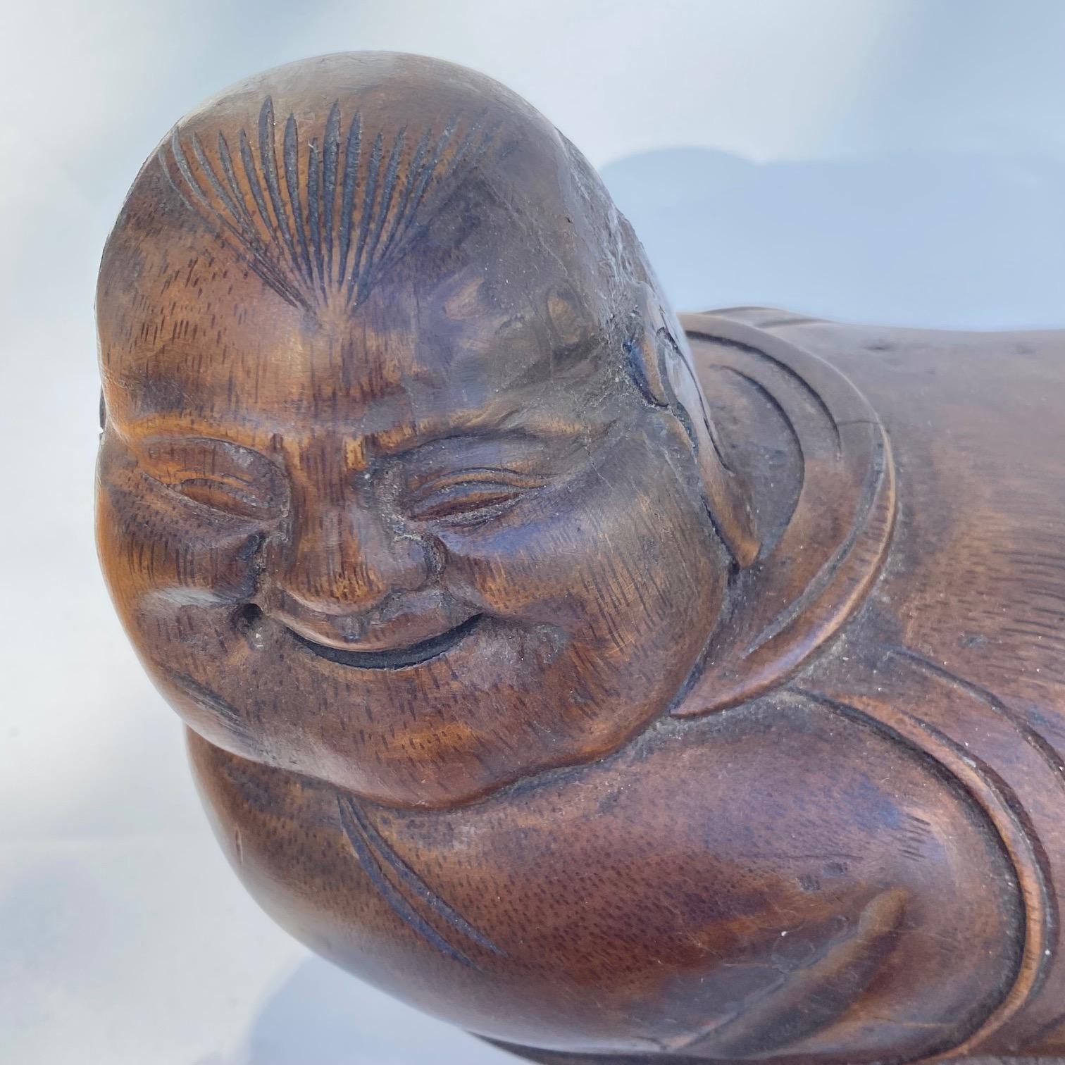 An interesting Chinese Pillow hand craved from Bamboo Hotei the god of the happiness buddha smiles and his little shoes are showing!