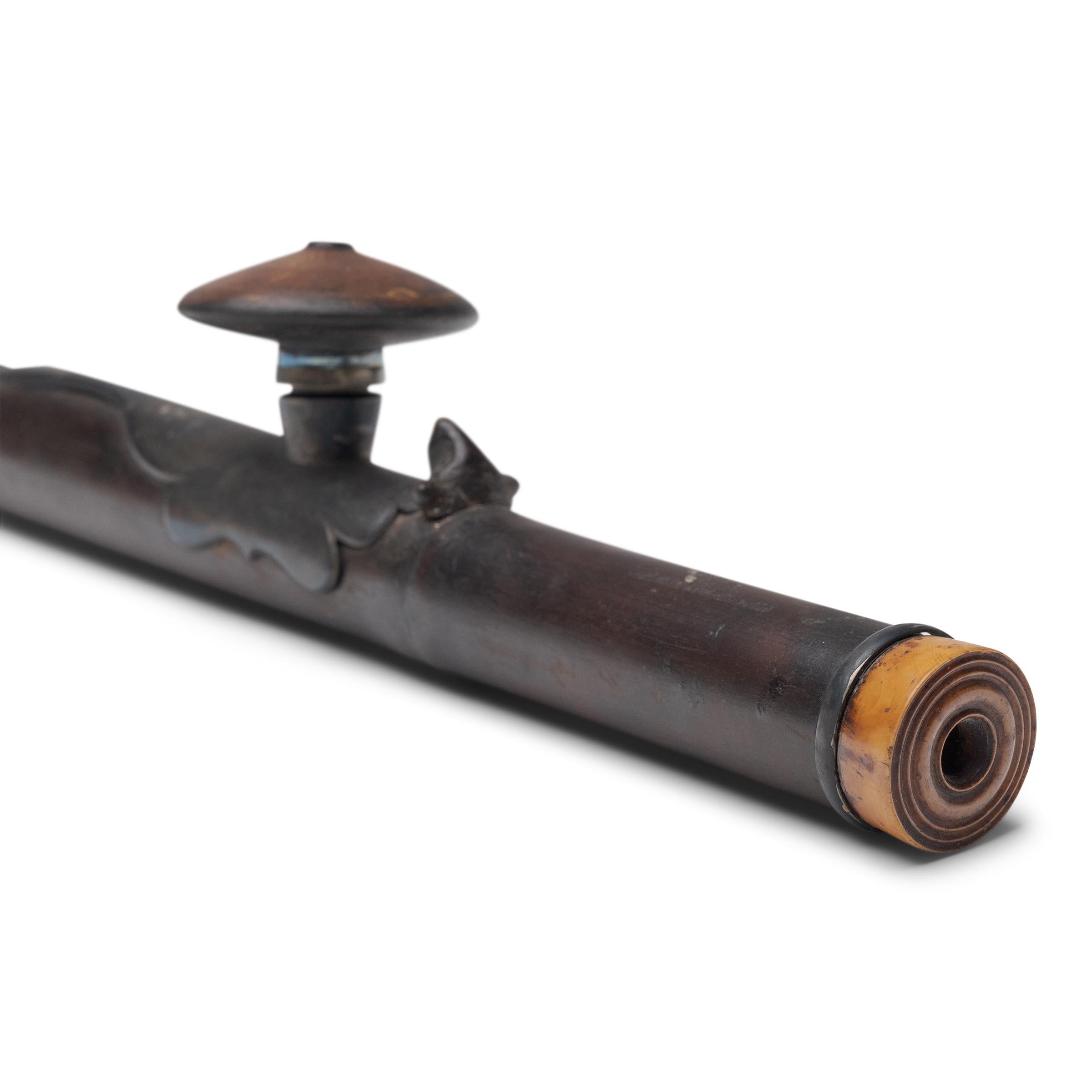 This long bamboo pipe dates to the late 19th century and was originally used for smoking opium. Unlike a tobacco pipe, the opium pipe was designed especially to allow resinous opium to be vaporized, rather than burned. Consequently, opium pipes have