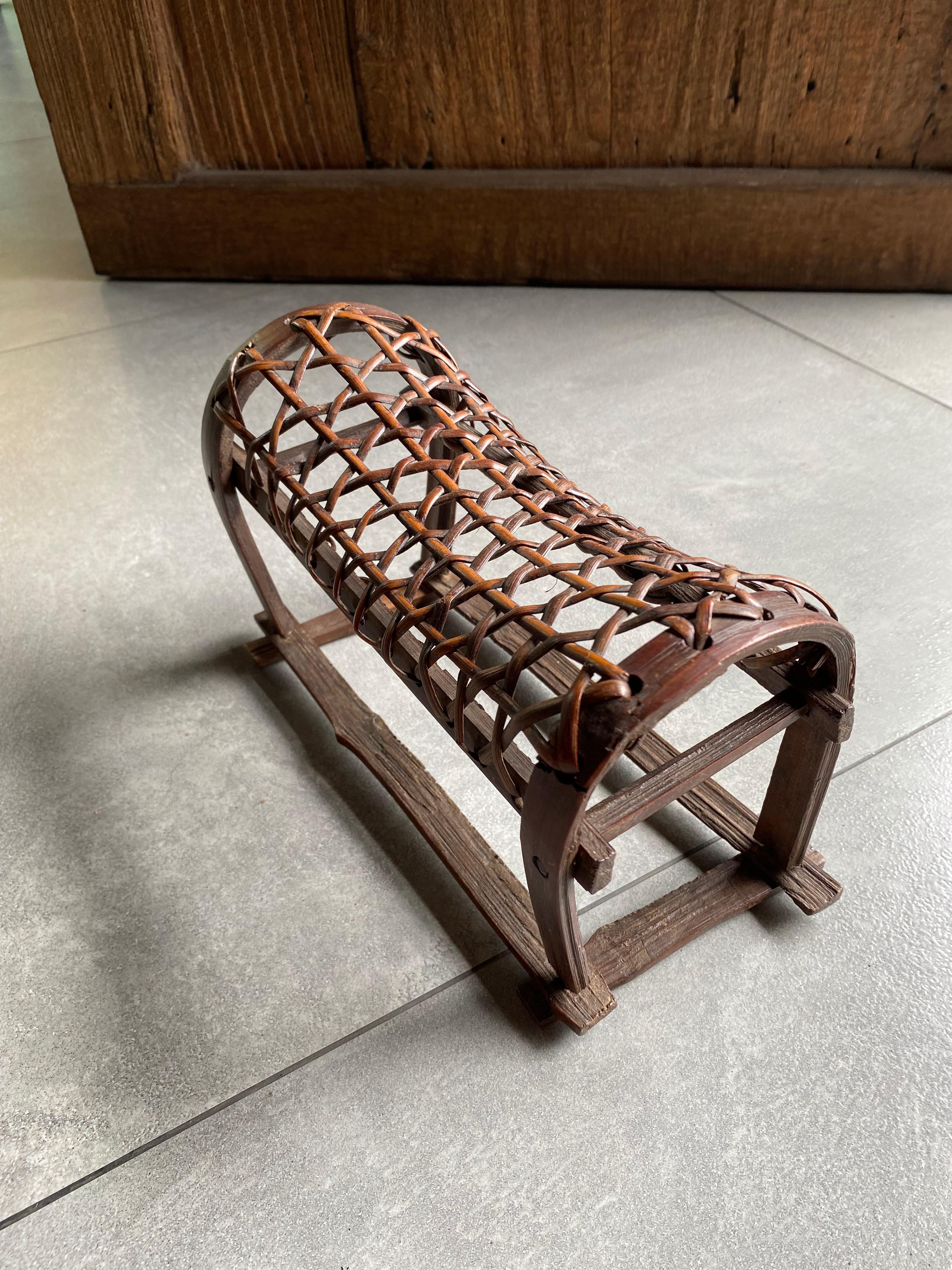 This Chinese headrest was once used in an opium smoke house for a smoker to rest while intoxicated. It is hand-crafted from split bamboo and rattan with an elegantly curved shape. 

Dimensions: Height 14cm x Width 24cm x Depth 11cm.