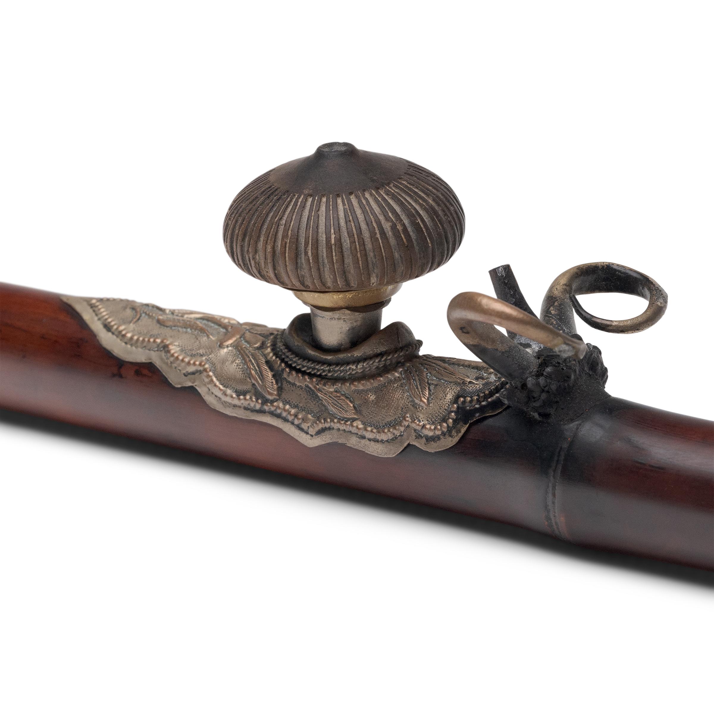 This long bamboo pipe dates to the early 20th century and was originally used for smoking opium. Unlike a tobacco pipe, the opium pipe was designed especially to allow resinous opium to be vaporized, rather than burned. Consequently, opium pipes