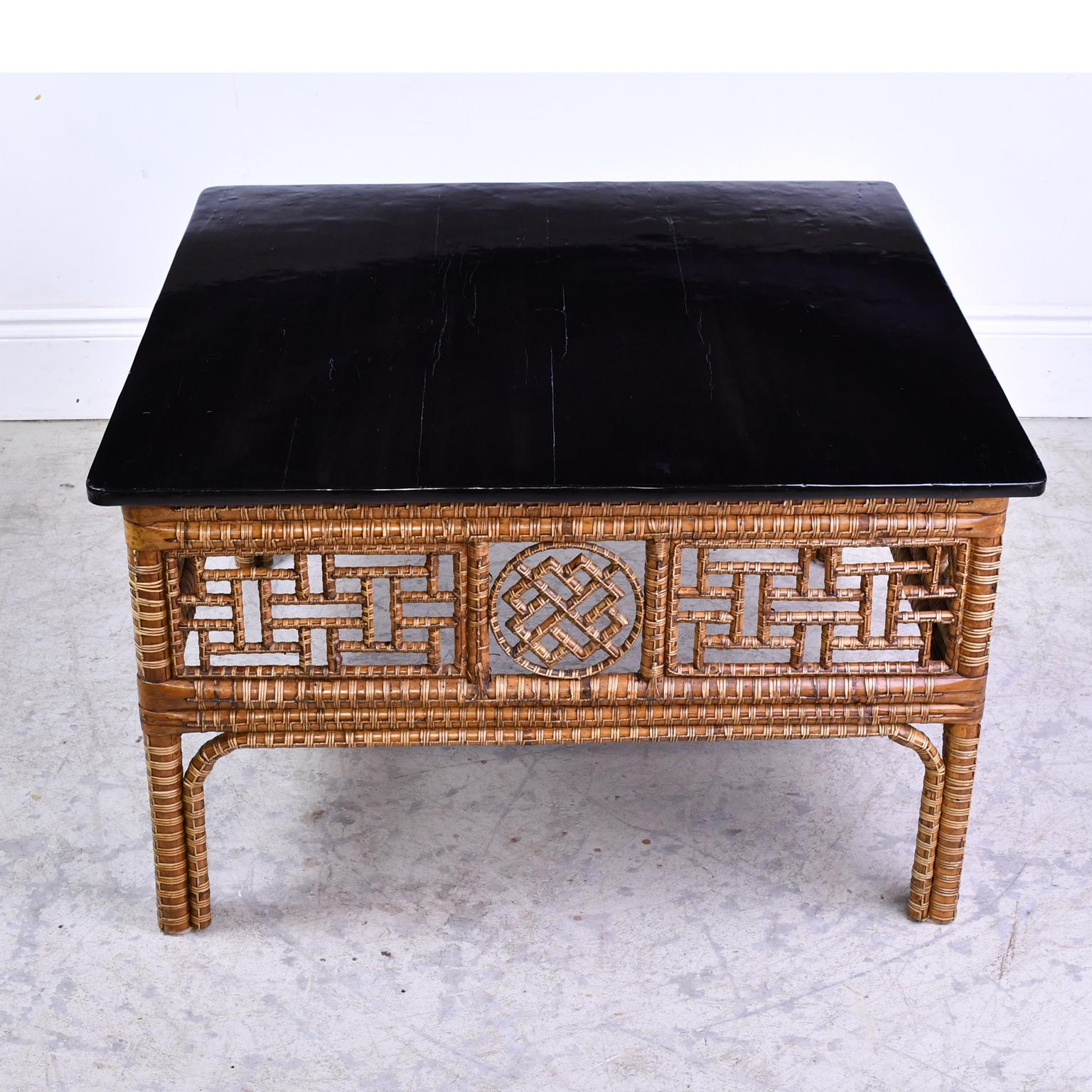 An exquisite Chinese table with square black-lacquered top over an intricately woven bamboo frame with four legs and an open geometric design on the apron. China, circa 1850.
Measures: 38
