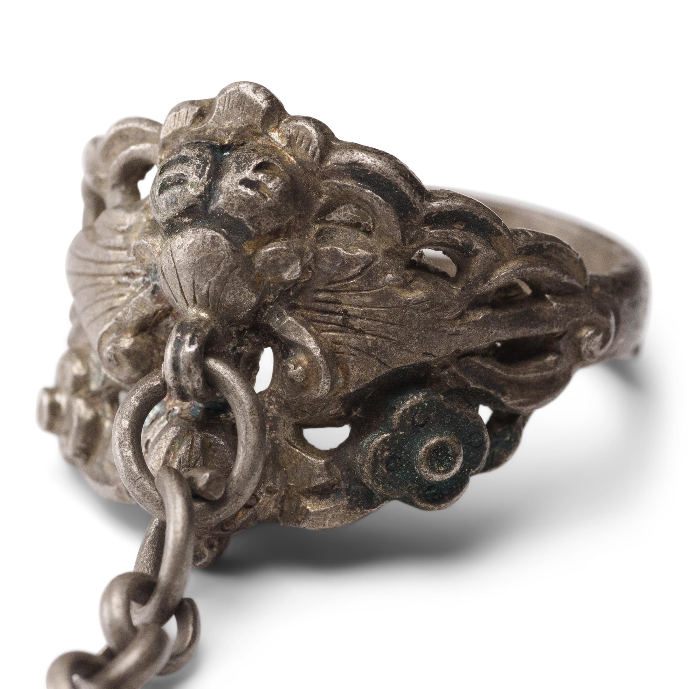 Dated to the late 19th century, this silver charm ring was crafted by the Miao peoples of the Guizhou province and was believed to protect the wearer from bad luck and malevolent spirits. The ring is decorated with a pierced, low relief design of a