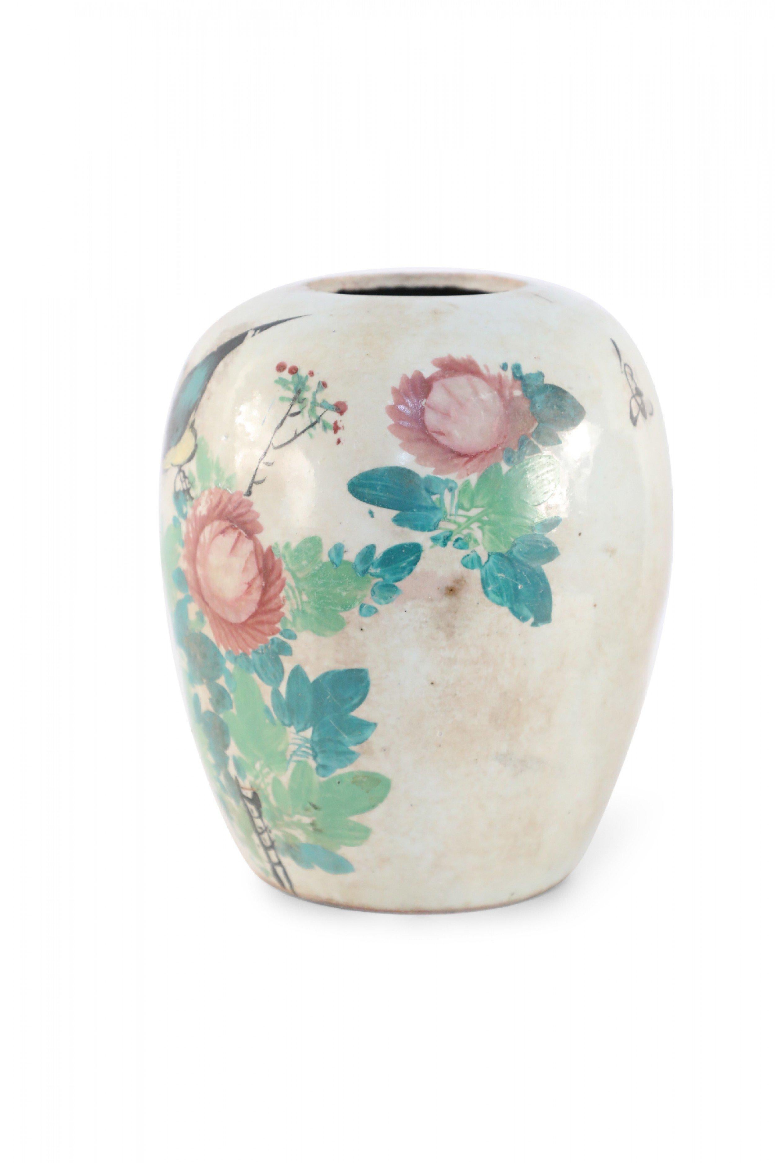 Vase antique chinois (début du 20e siècle) en porcelaine bulbeuse avec des fleurs roses et un oiseau à la poitrine jaune au milieu de feuilles vertes sur une face et des caractères sur le revers. Il y a des craquelures mouchetées sur la glaçure.
 