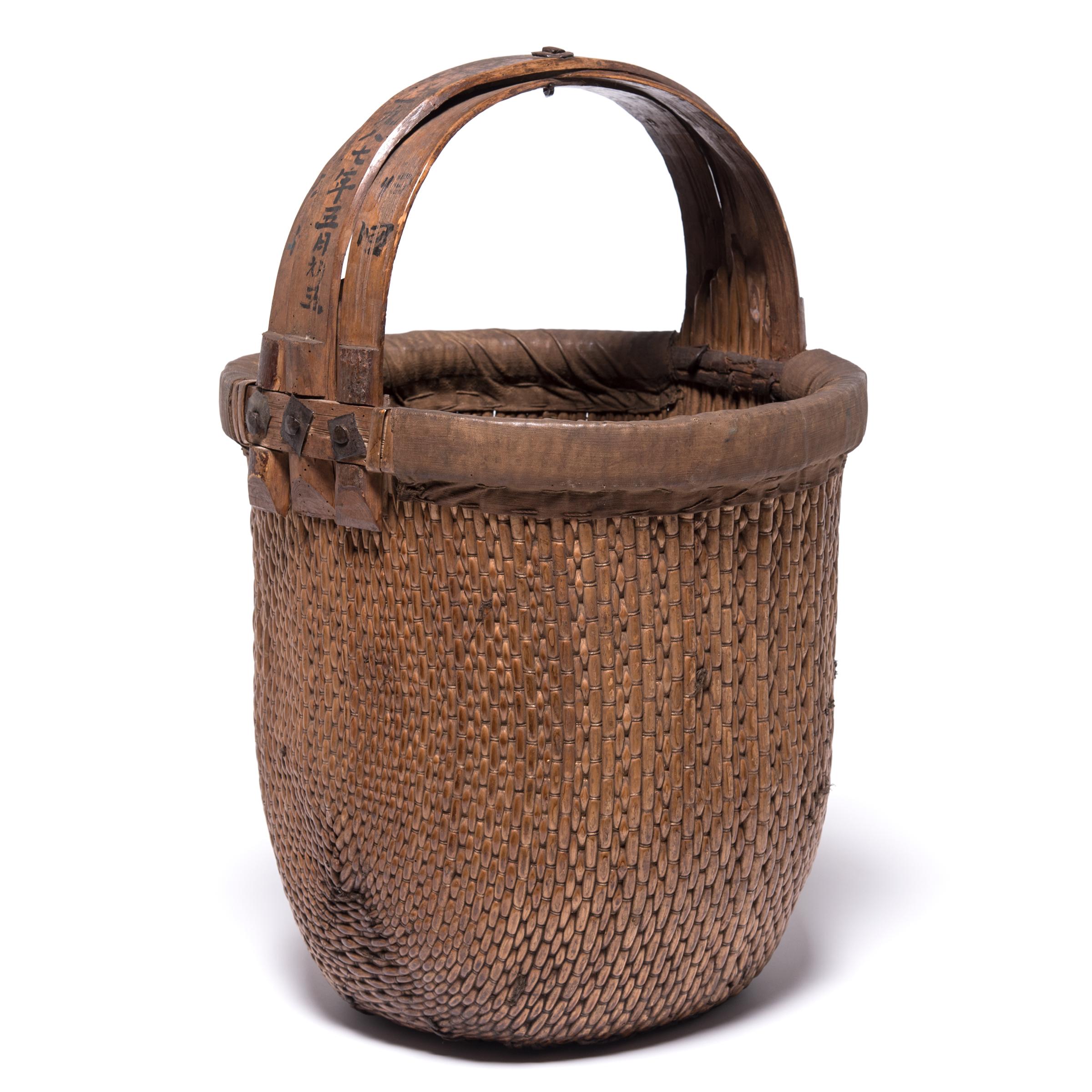 Basket making is an ancient and humble craft, but in the hands of a skilled weaver a simple willow basket can become a truly beautiful work of art. This bent handle basket was made in China long ago, and the artisan’s mastery is evident: the strong,
