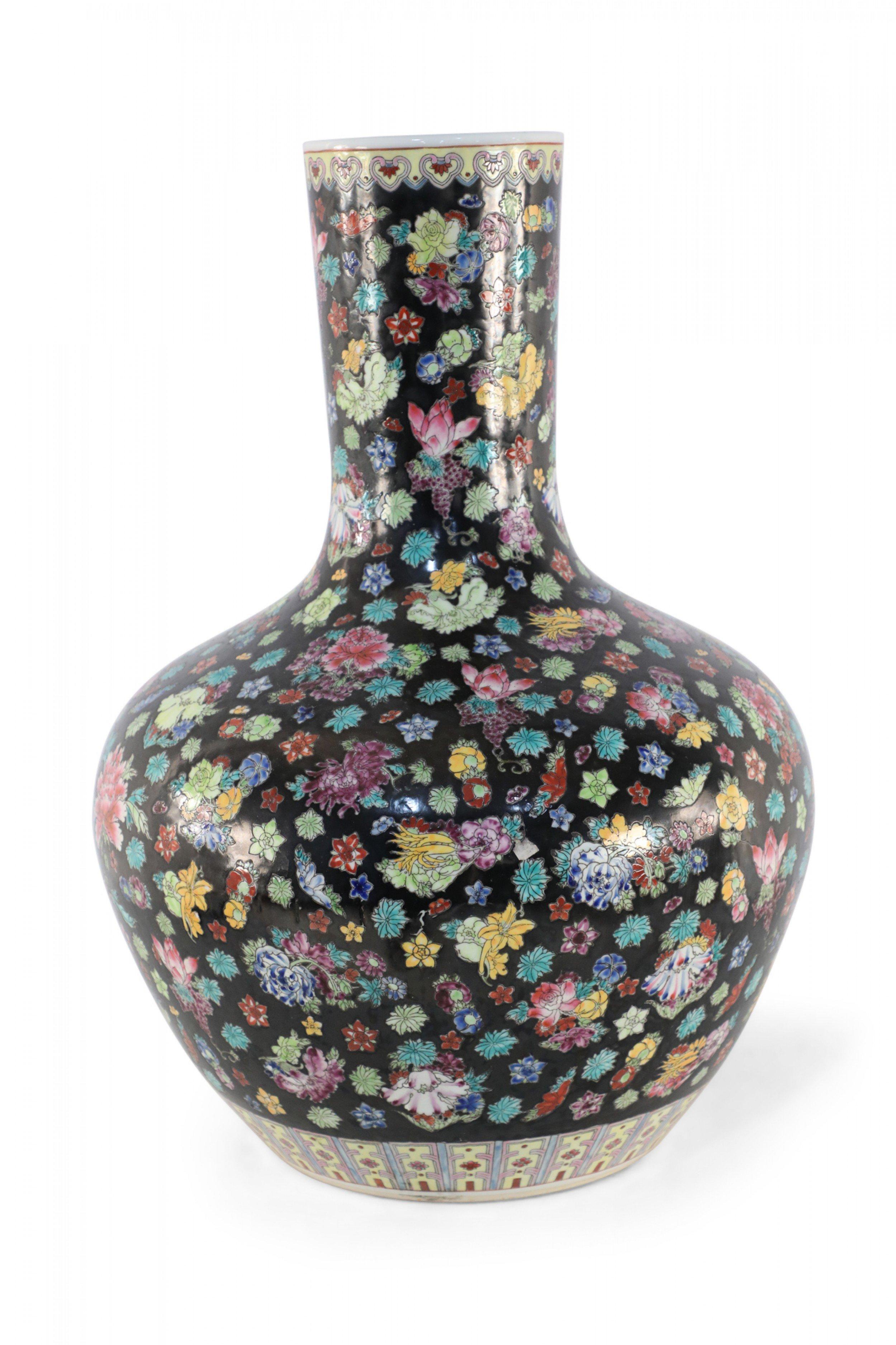 Chinese black porcelain vase decorated with an abundance of flowers varying in size, shape and color and two patterned bands around the top and base.
 